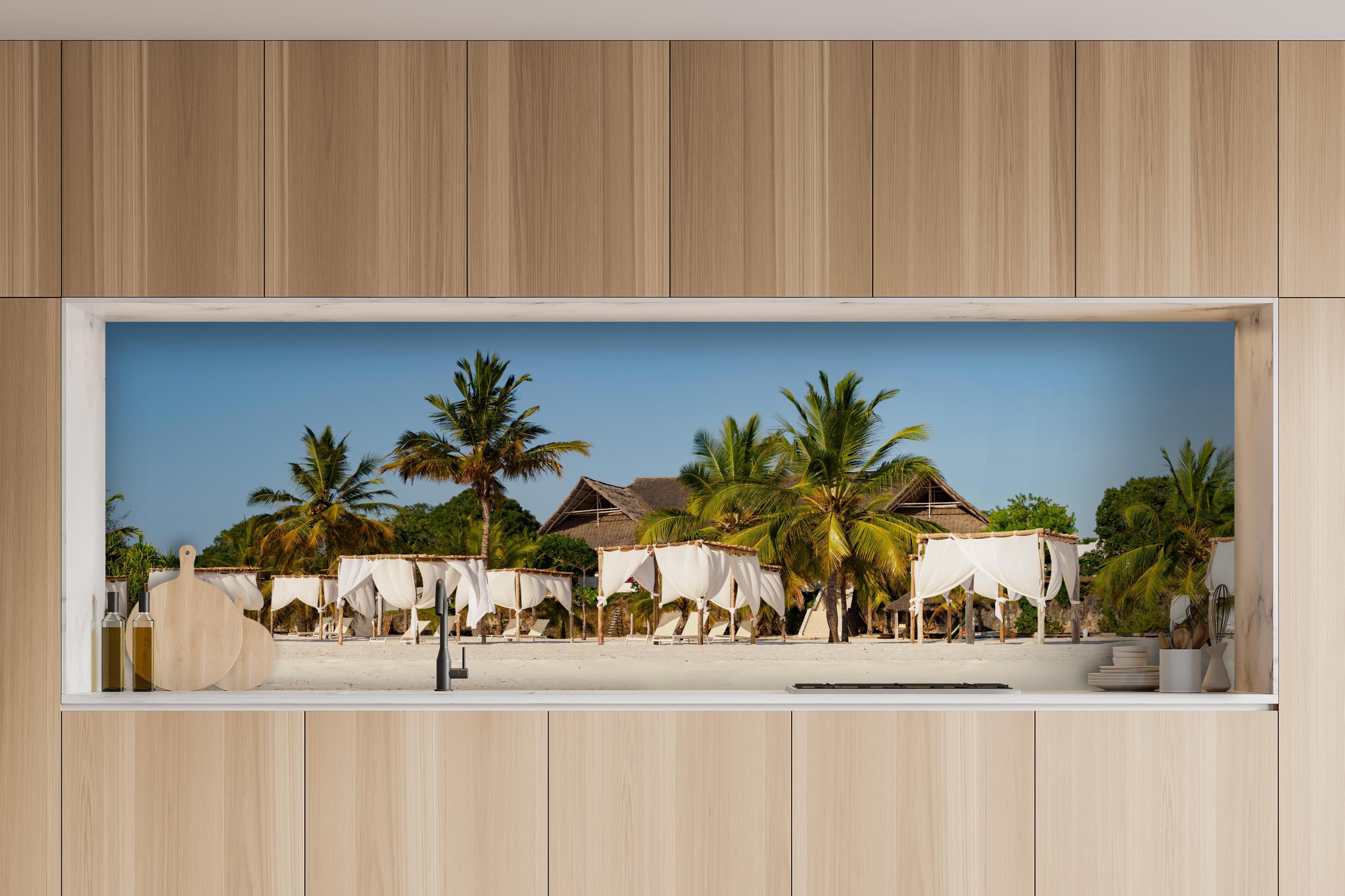 Küche - Schöner Strand mit Liegen hinter weißen Hochglanz-Küchenregalen und schwarzem Wasserhahn