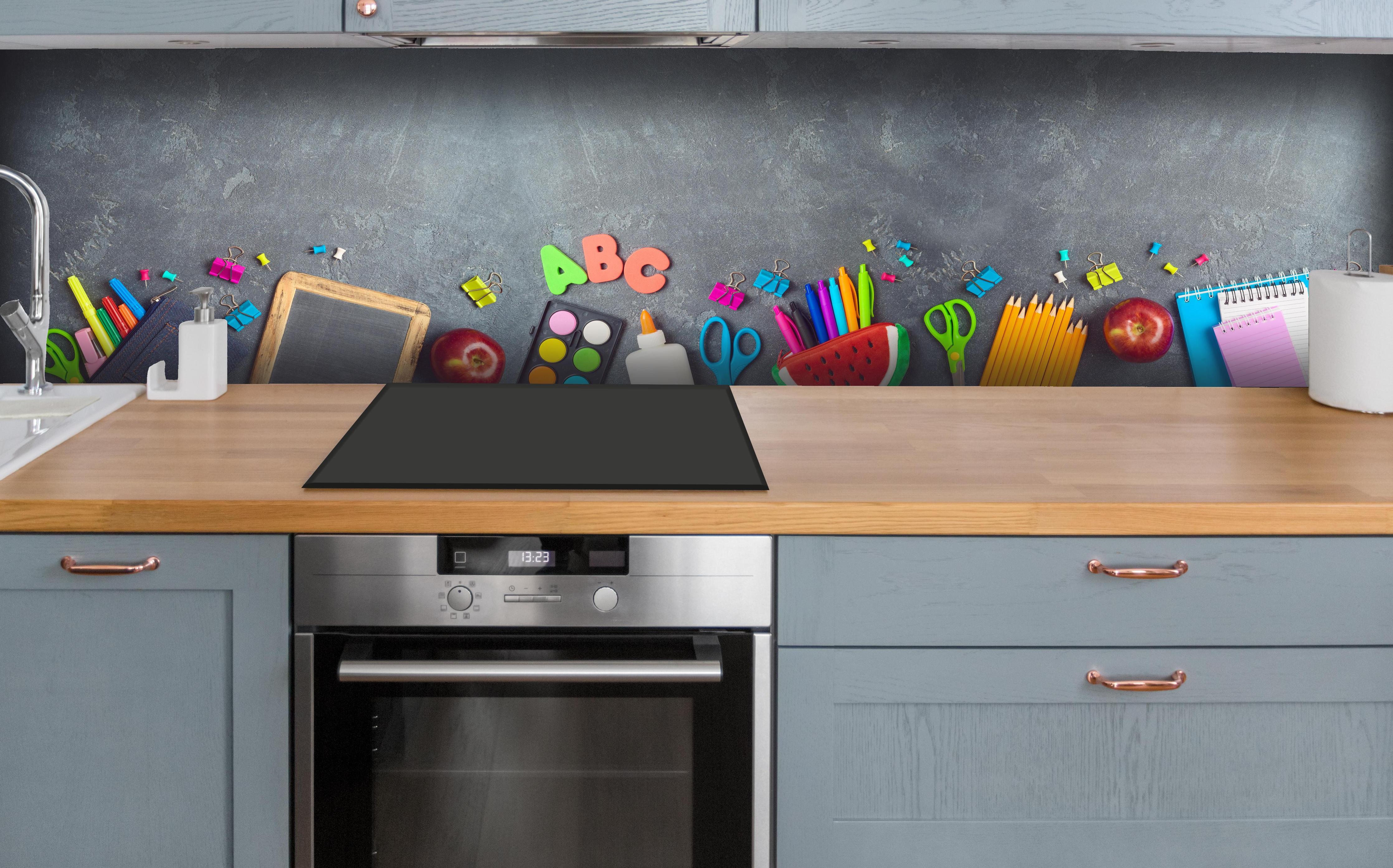 Küche - Schulbedarf auf Tafel für den Schulstart hinter weißen Hochglanz-Küchenregalen und schwarzem Wasserhahn