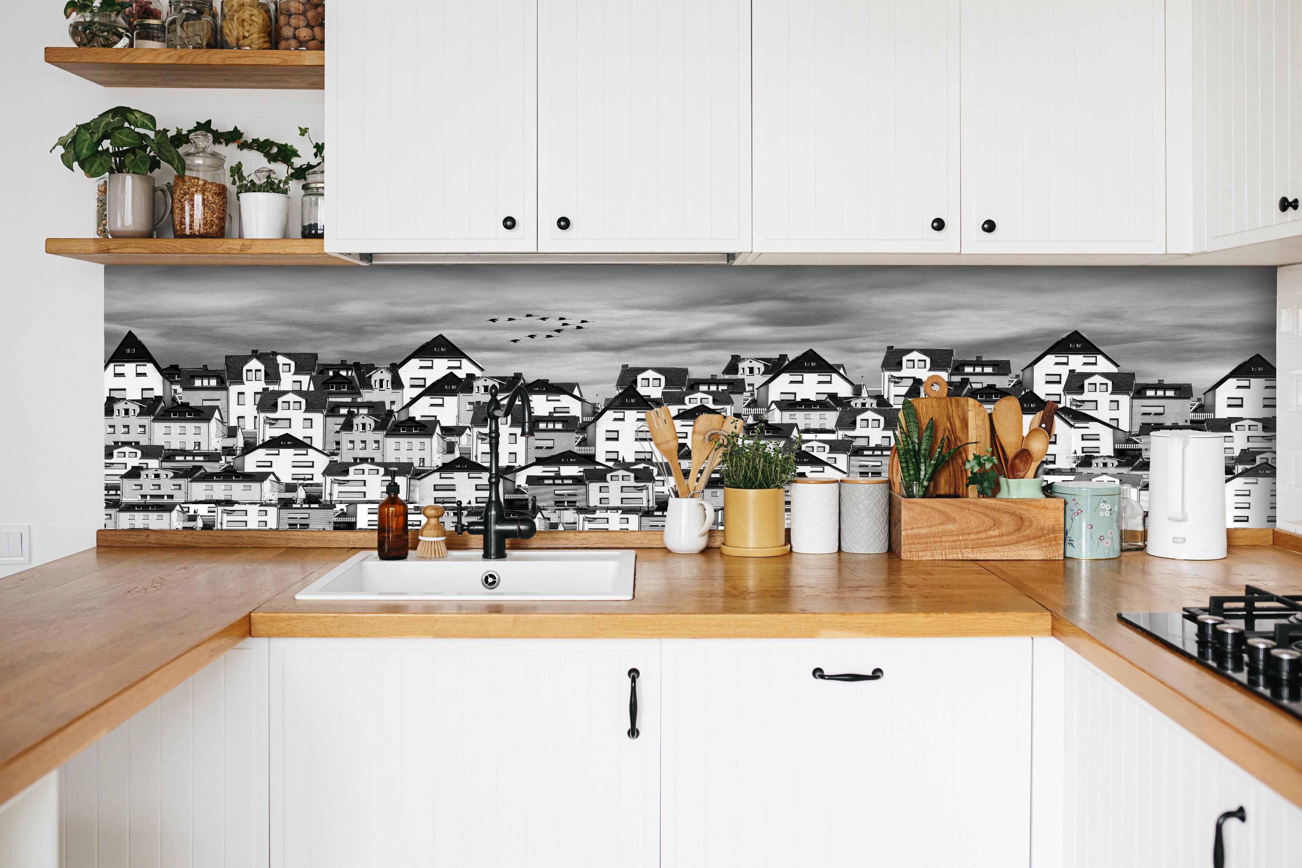 Küche - Schwarz-weiße Dachlandschaft mit Vögeln hinter weißen Hochglanz-Küchenregalen und schwarzem Wasserhahn