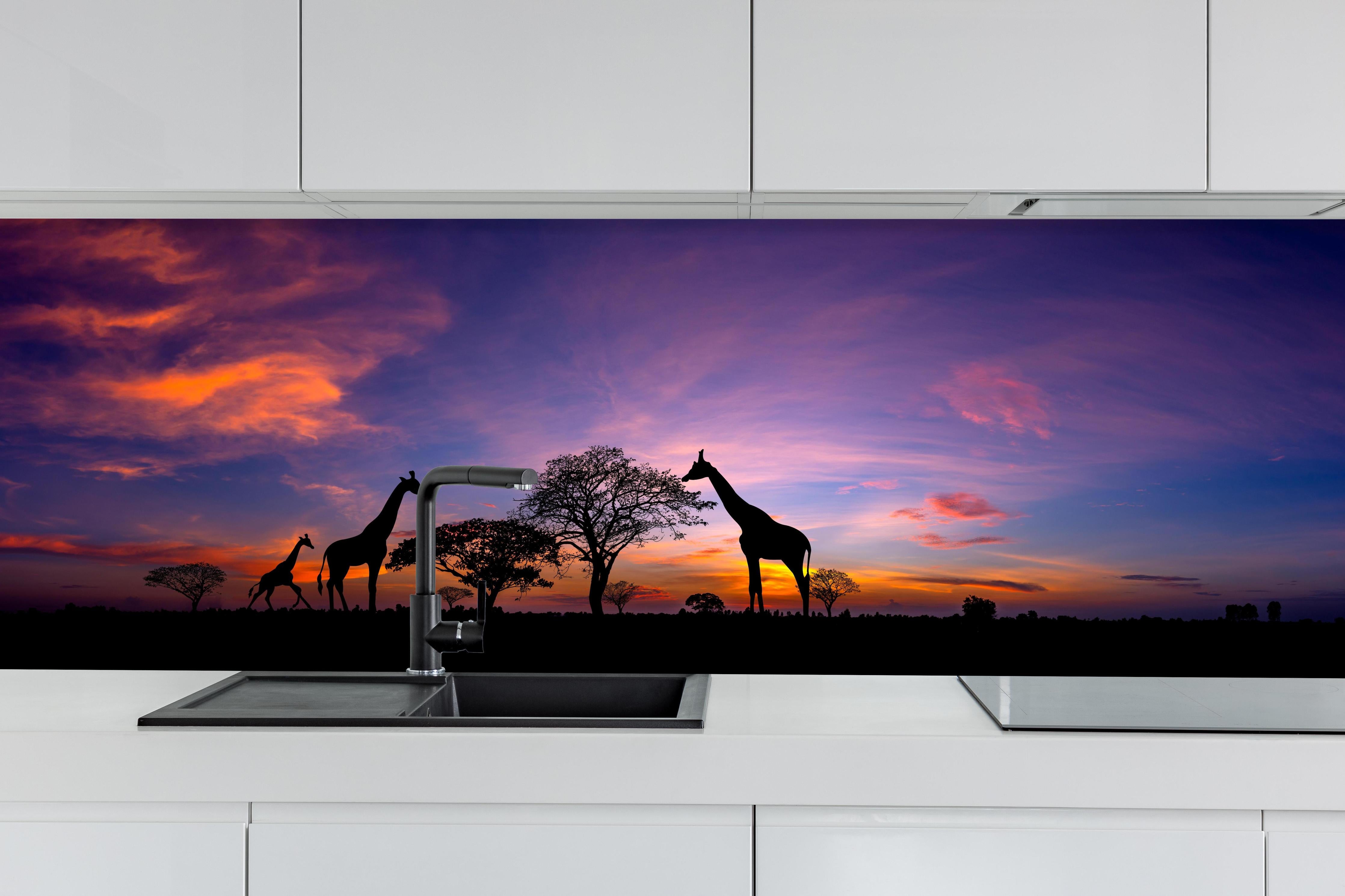 Küche - Silhouette - Giraffenfamilie bei Sonnenuntergang hinter weißen Hochglanz-Küchenregalen und schwarzem Wasserhahn