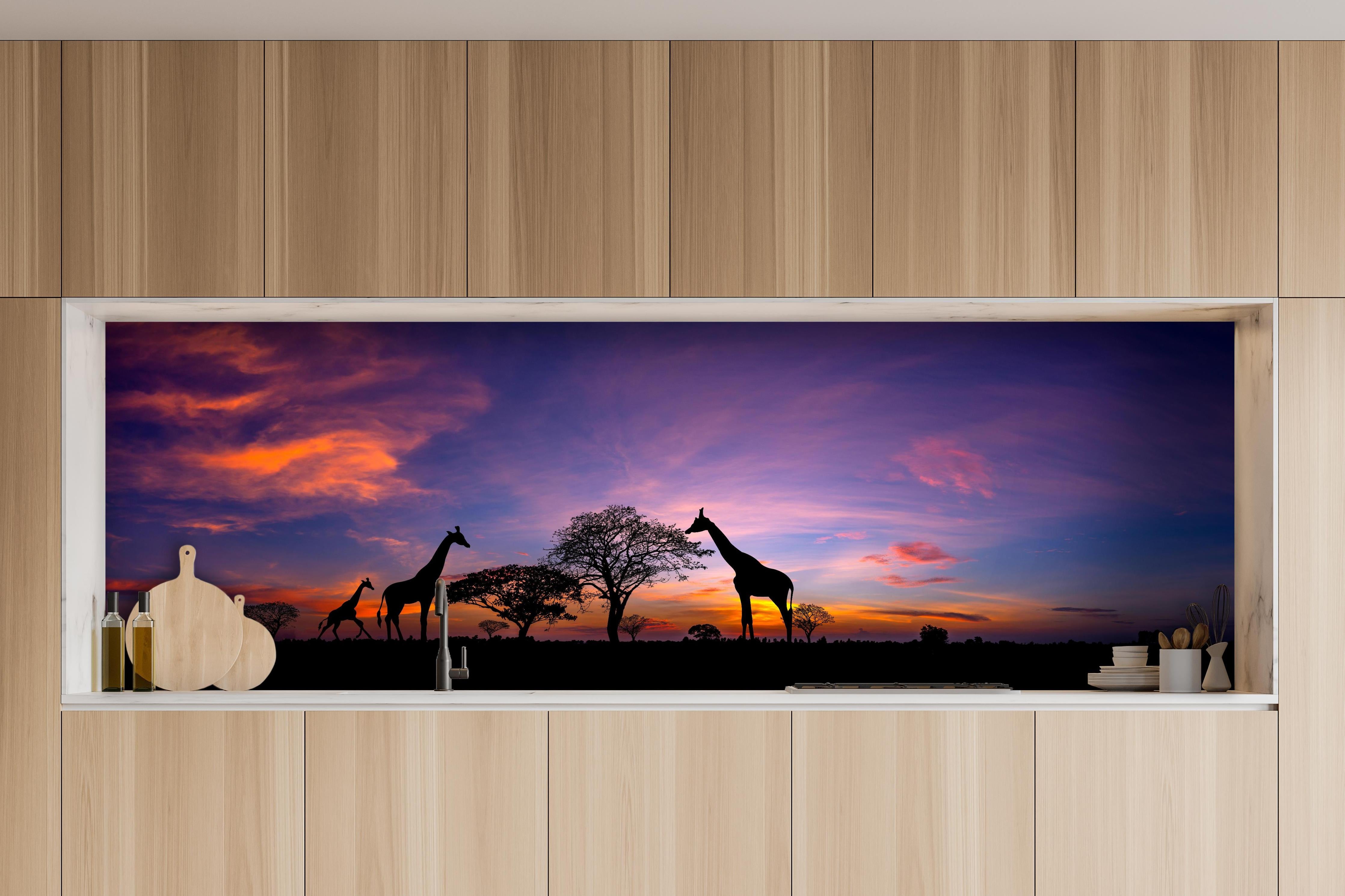 Küche - Silhouette - Giraffenfamilie bei Sonnenuntergang hinter weißen Hochglanz-Küchenregalen und schwarzem Wasserhahn