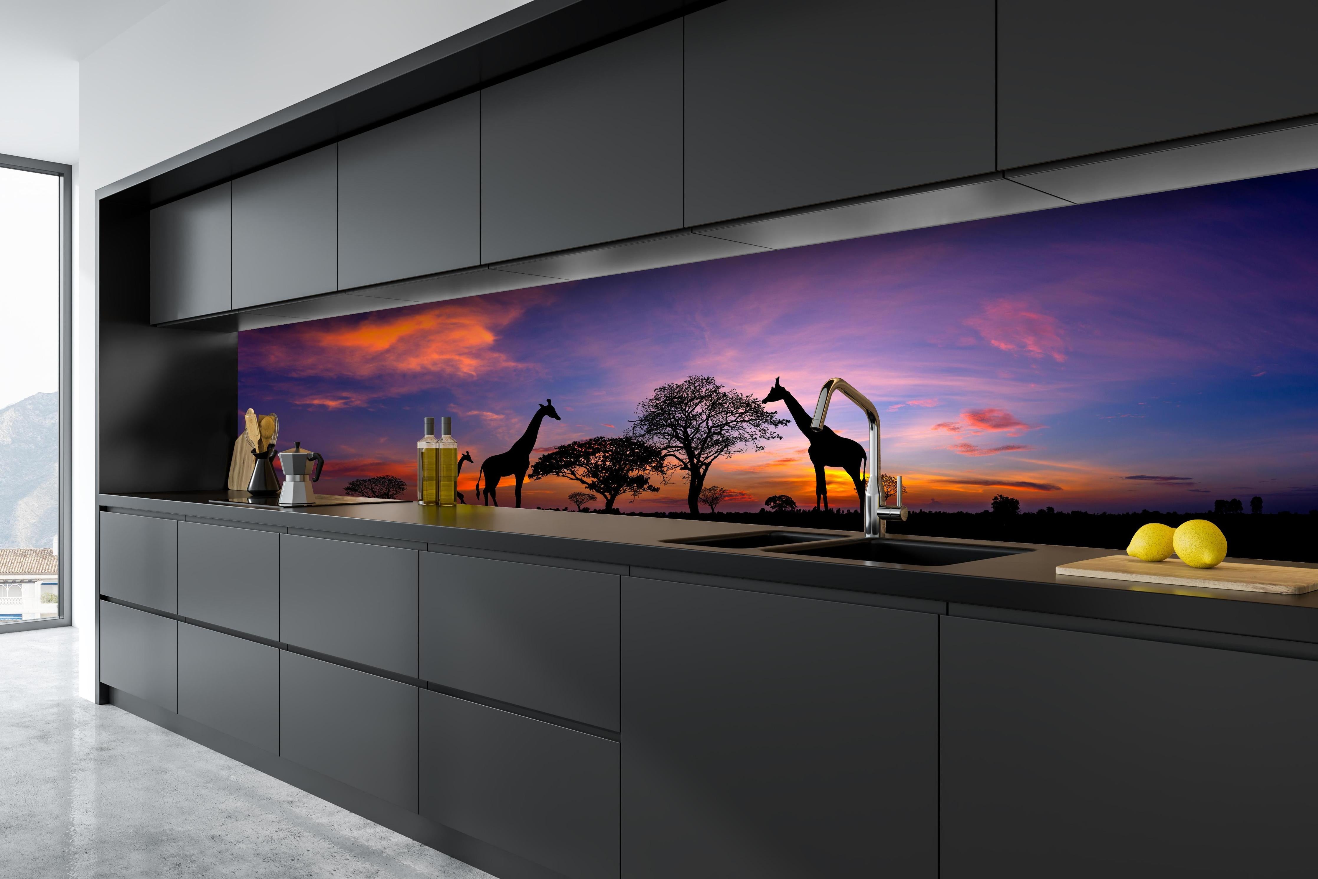 Küche - Silhouette - Giraffenfamilie bei Sonnenuntergang hinter weißen Hochglanz-Küchenregalen und schwarzem Wasserhahn