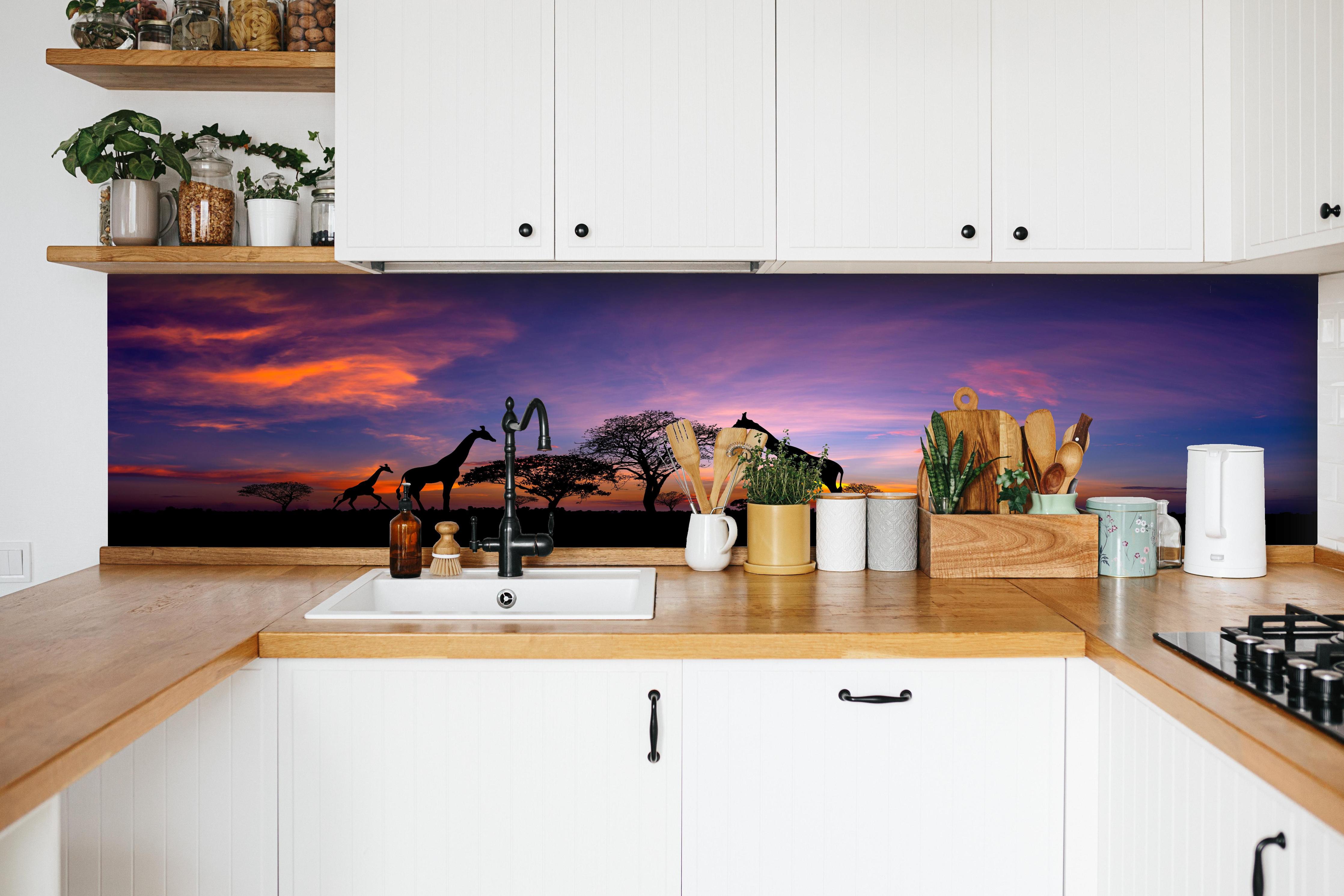 Küche - Silhouette - Giraffenfamilie bei Sonnenuntergang hinter weißen Hochglanz-Küchenregalen und schwarzem Wasserhahn