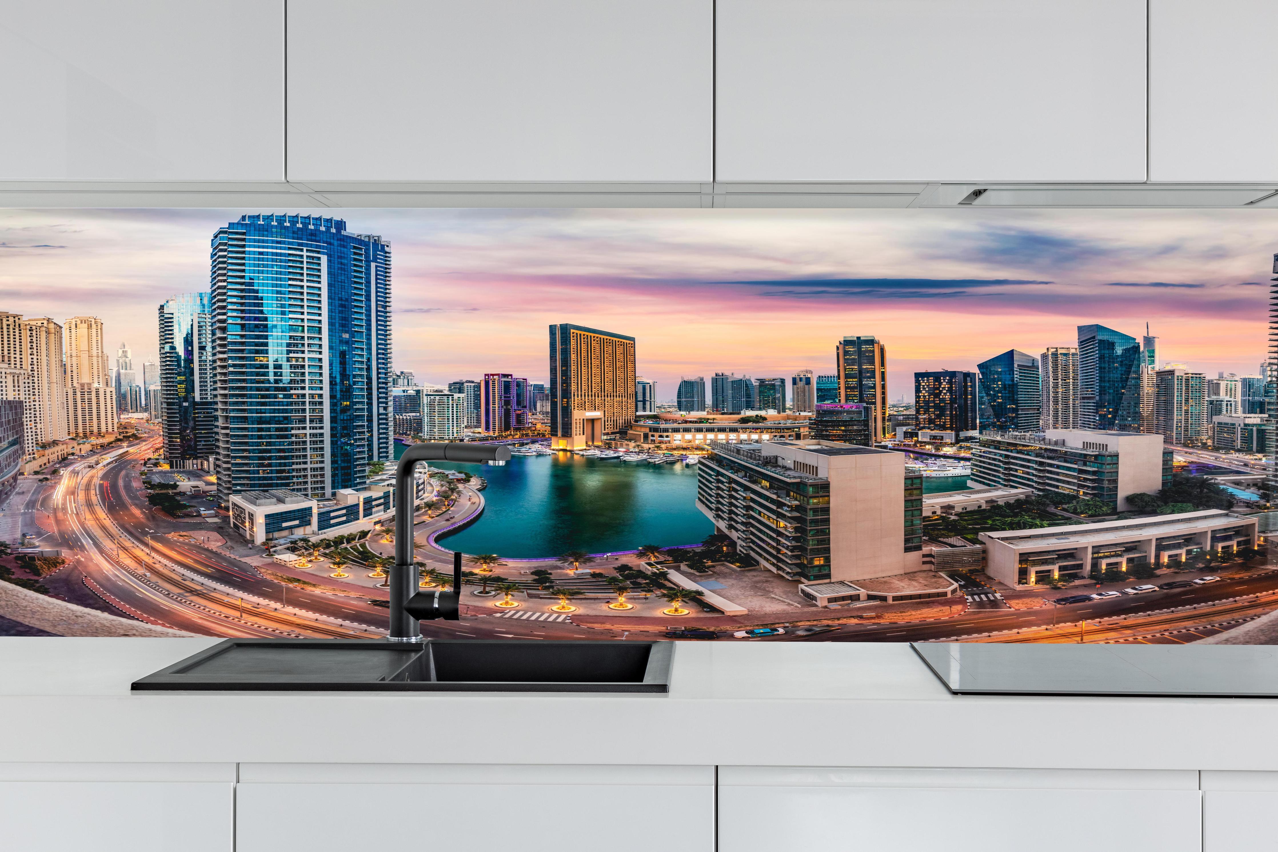 Küche - Skyline des Jachthafens von Dubai bei Sonnenuntergang hinter weißen Hochglanz-Küchenregalen und schwarzem Wasserhahn