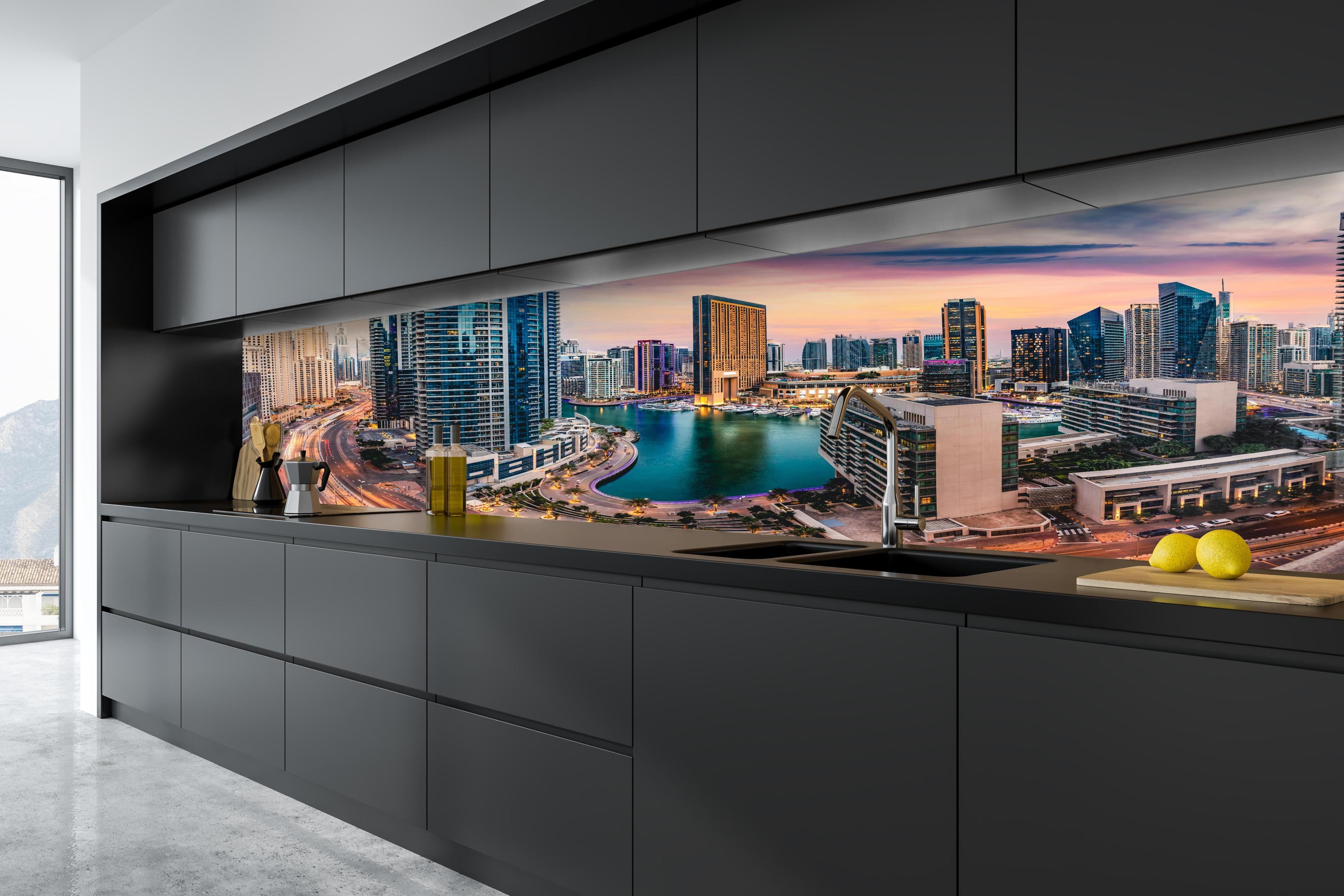 Küche - Skyline des Jachthafens von Dubai bei Sonnenuntergang hinter weißen Hochglanz-Küchenregalen und schwarzem Wasserhahn