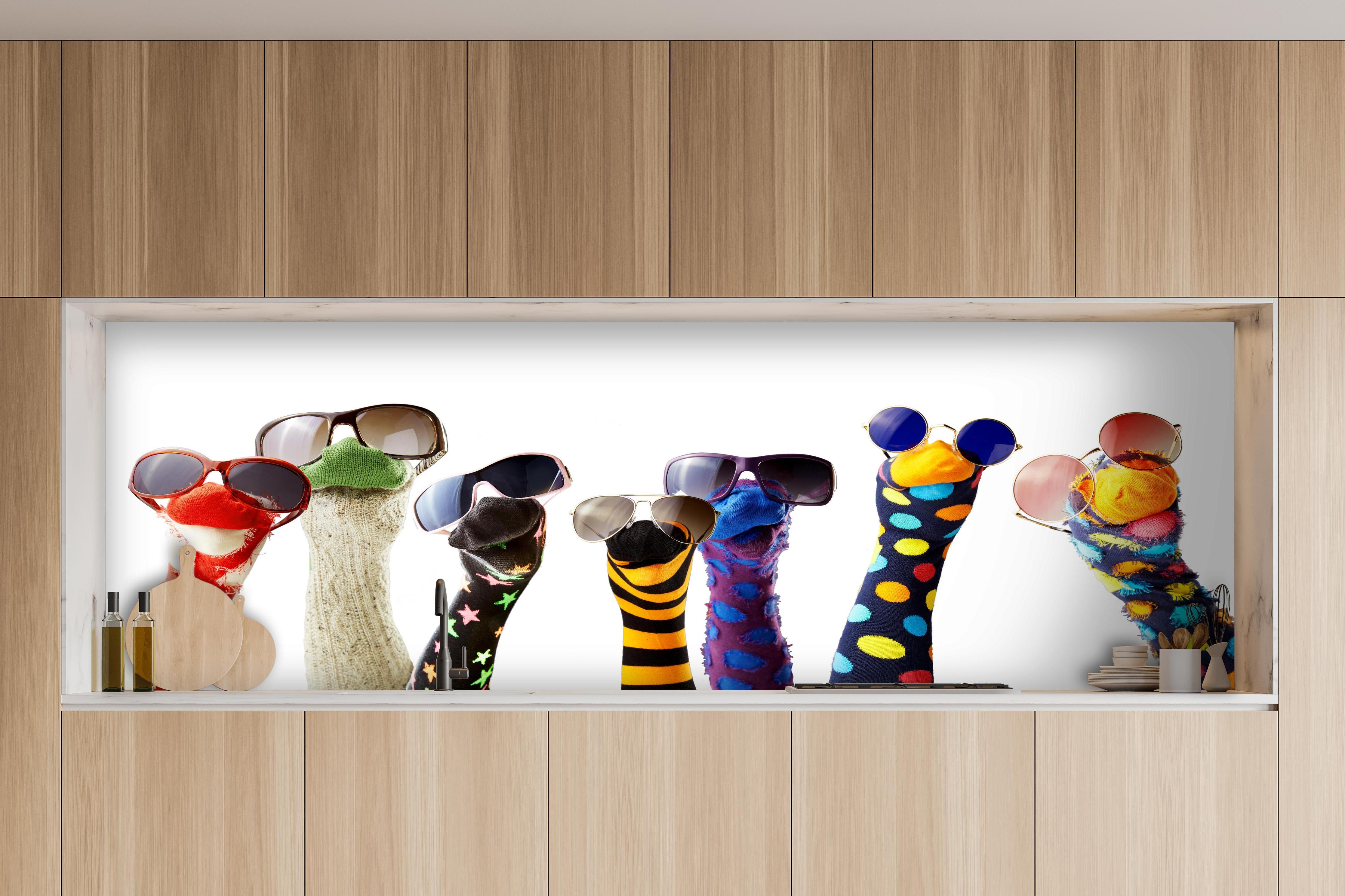 Küche - Sockenpuppen mit Brille hinter weißen Hochglanz-Küchenregalen und schwarzem Wasserhahn