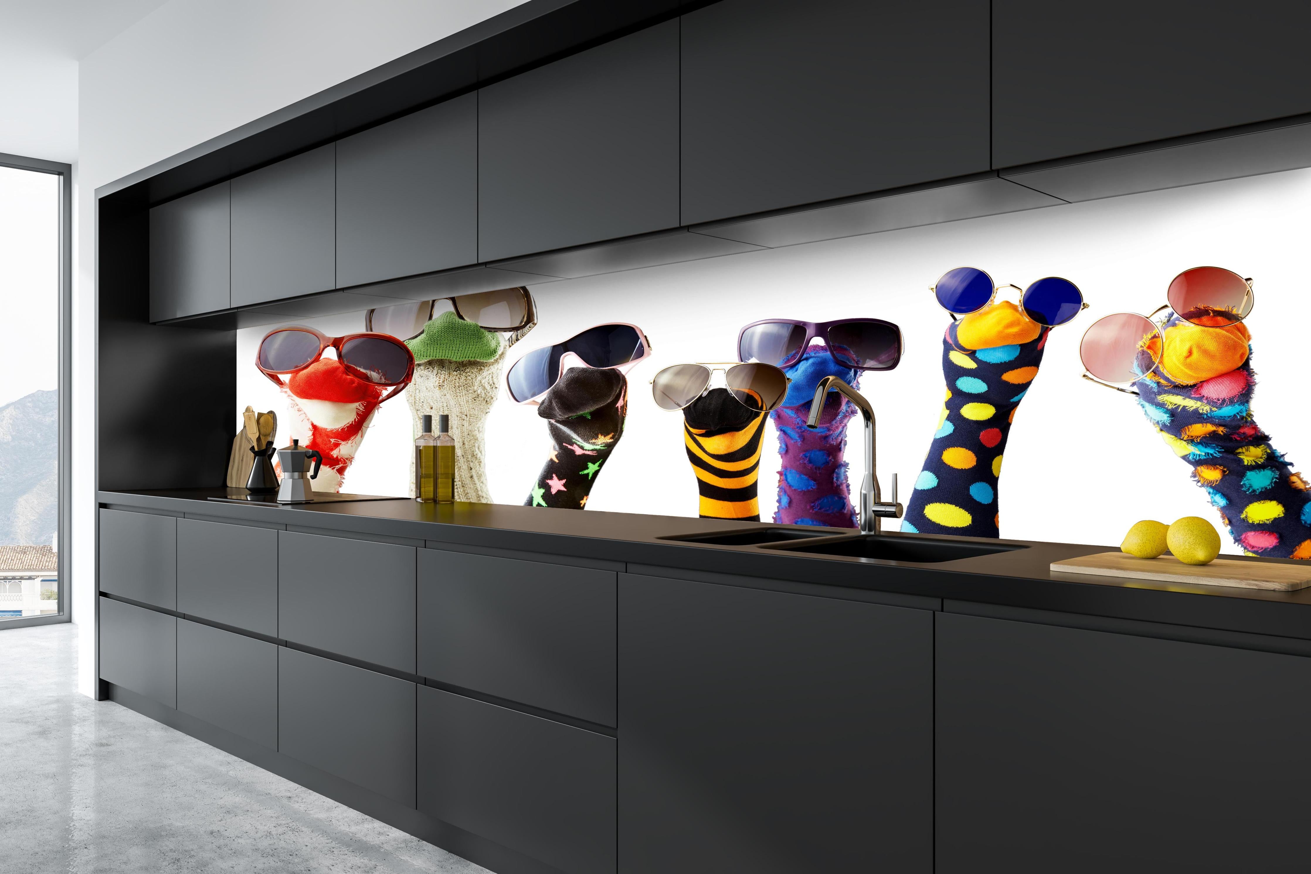 Küche - Sockenpuppen mit Brille hinter weißen Hochglanz-Küchenregalen und schwarzem Wasserhahn