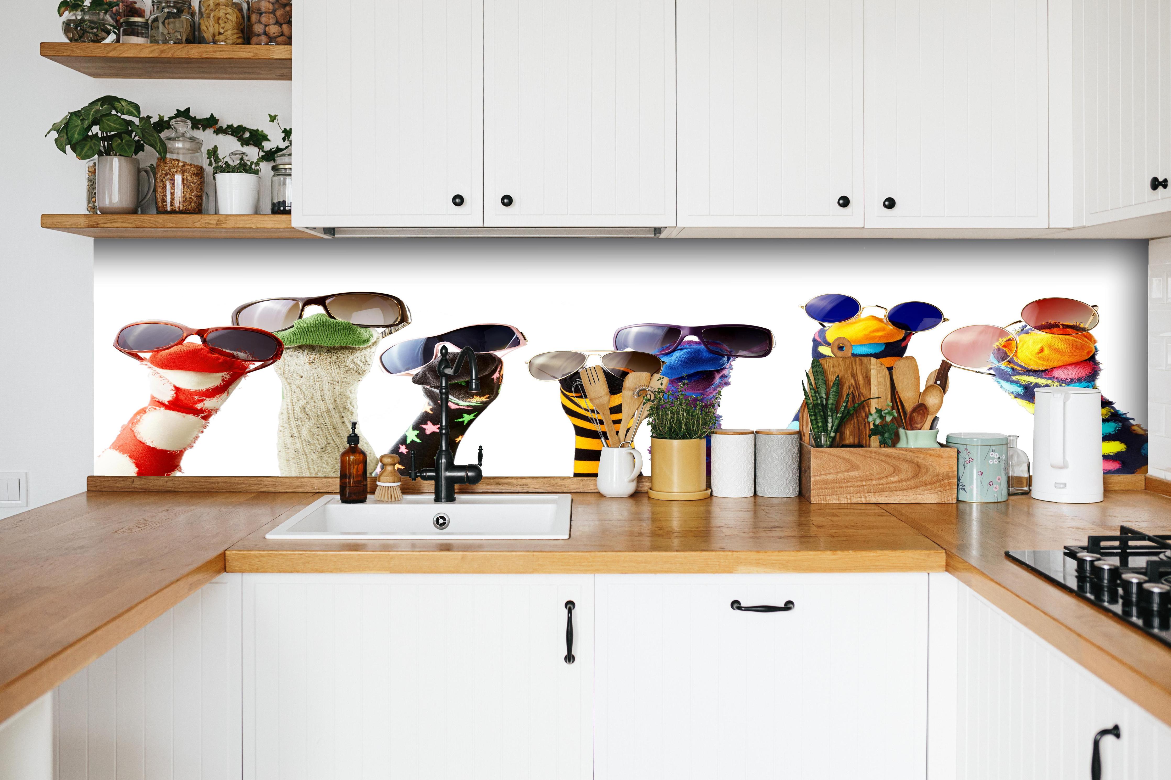 Küche - Sockenpuppen mit Brille hinter weißen Hochglanz-Küchenregalen und schwarzem Wasserhahn