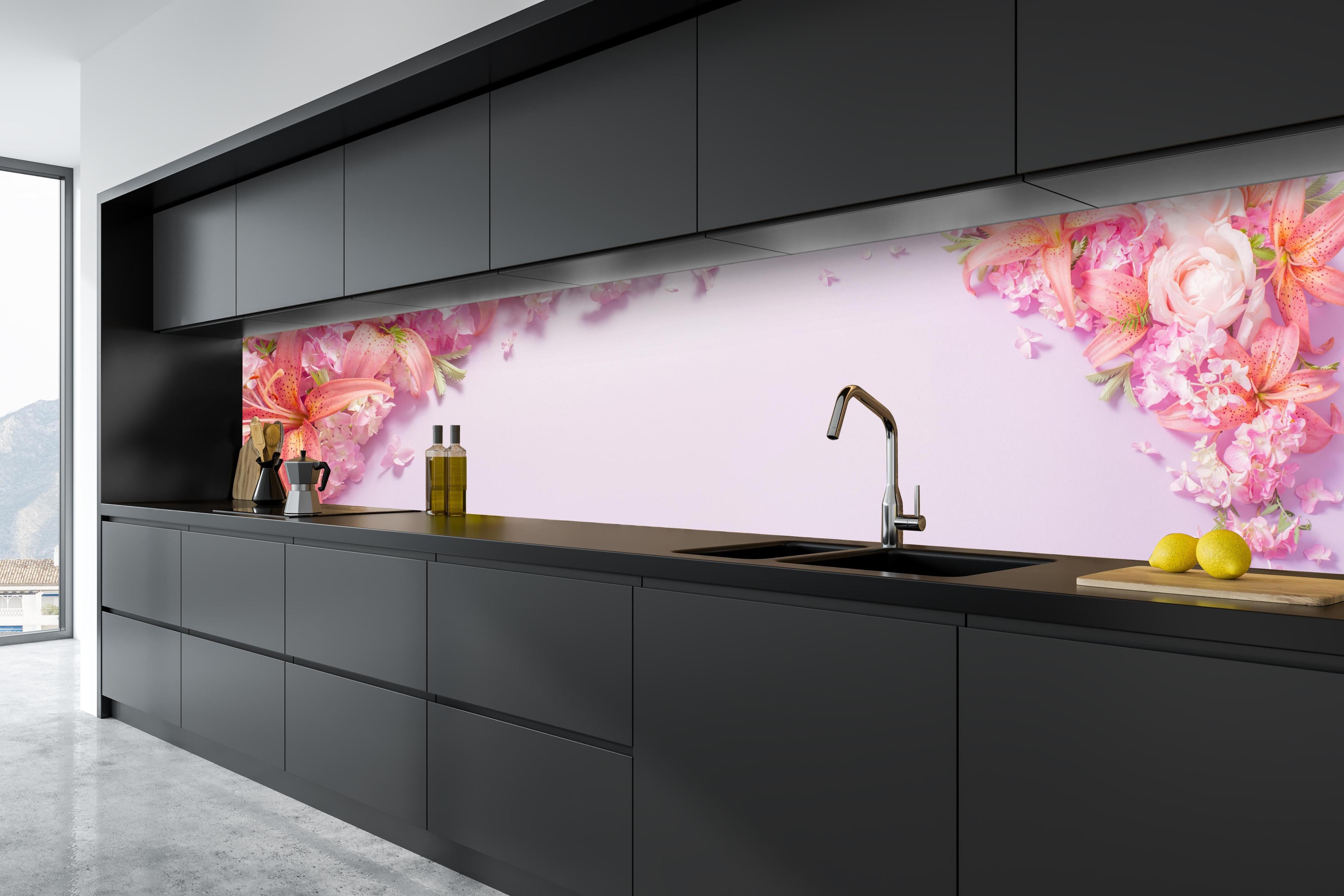 Küche - Sommerliche Blumenarrangements auf Papier hinter weißen Hochglanz-Küchenregalen und schwarzem Wasserhahn