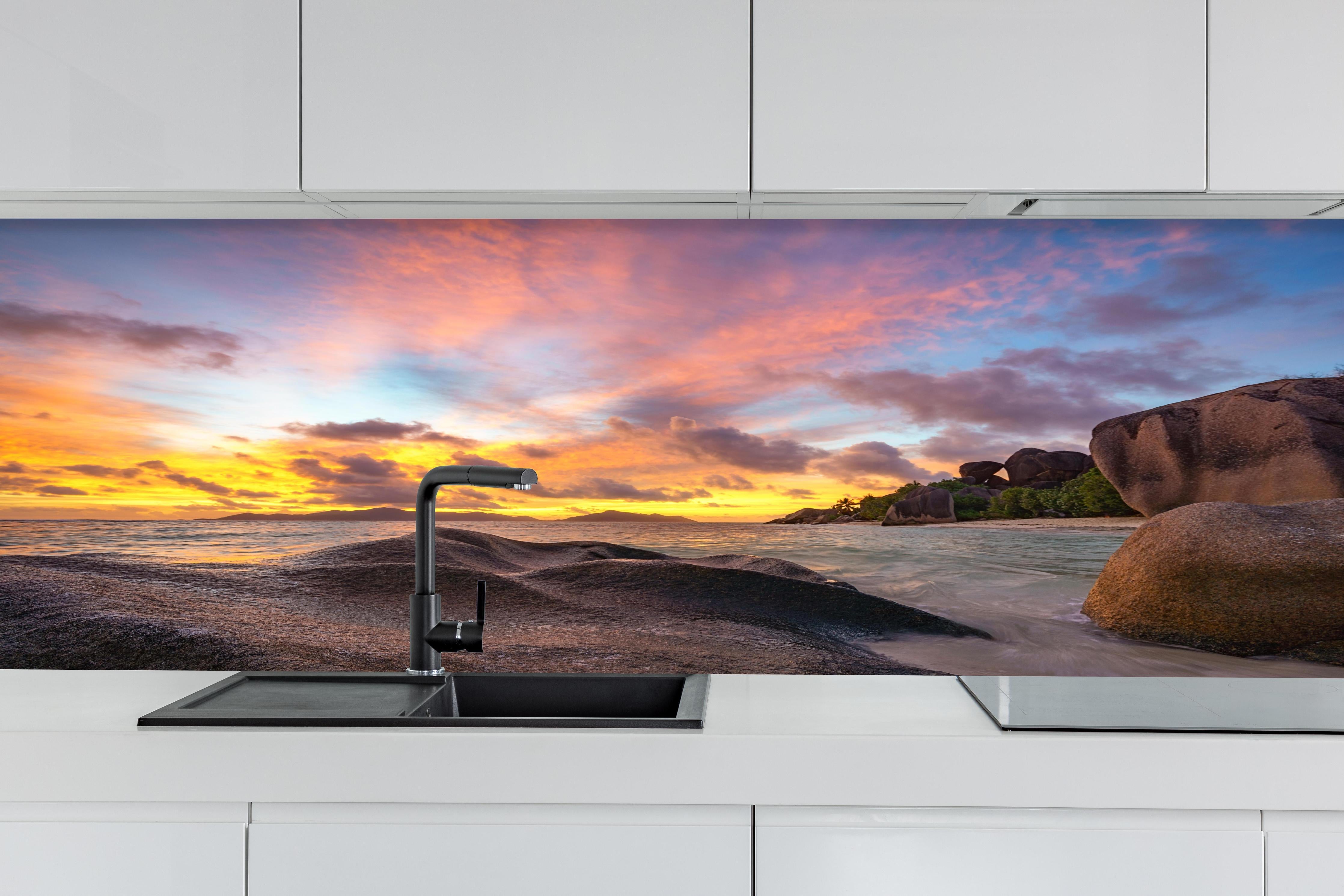 Küche - Sonnenuntergang am tropischen Strand hinter weißen Hochglanz-Küchenregalen und schwarzem Wasserhahn