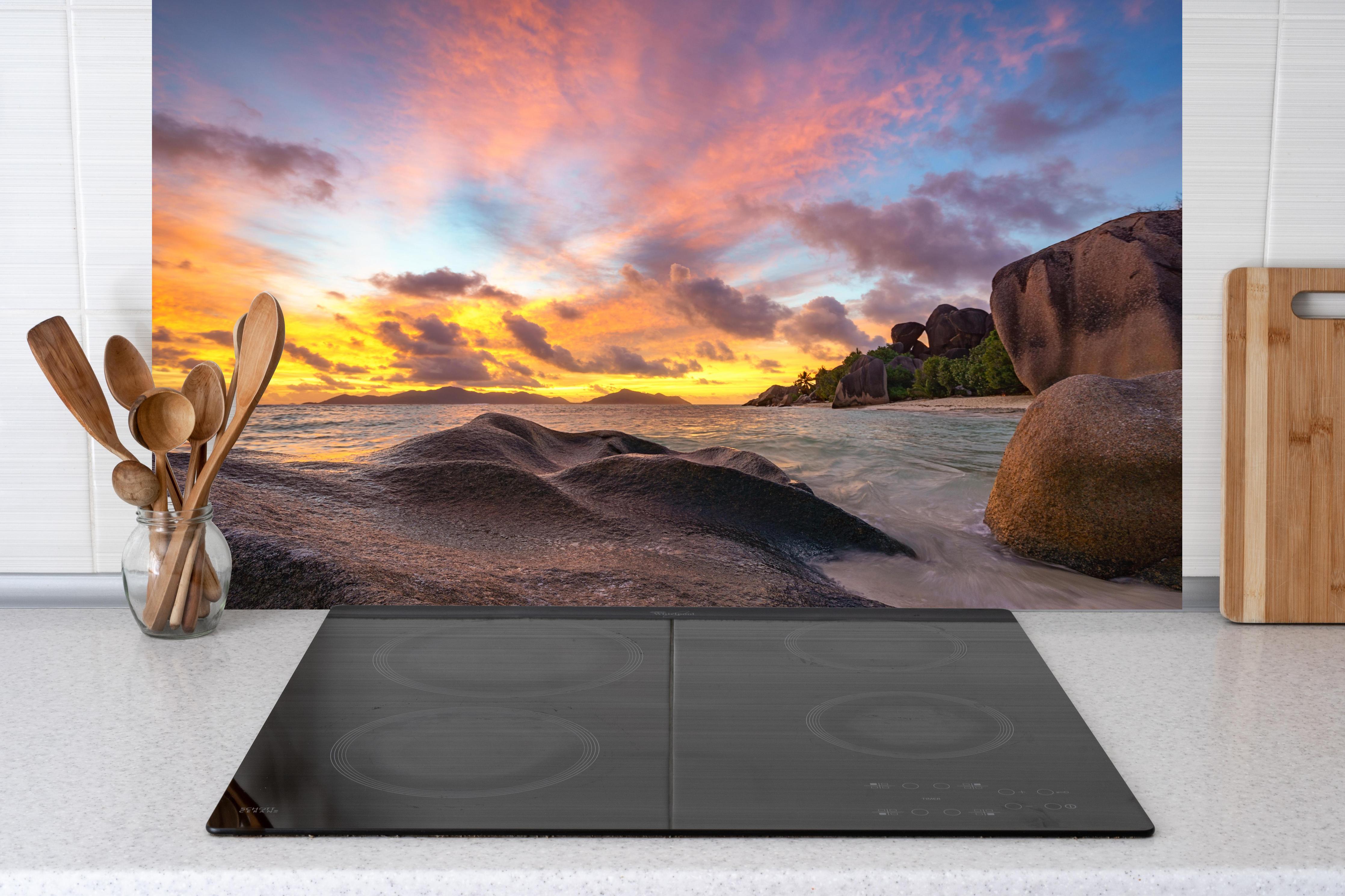 Küche - Sonnenuntergang am tropischen Strand hinter weißen Hochglanz-Küchenregalen und schwarzem Wasserhahn
