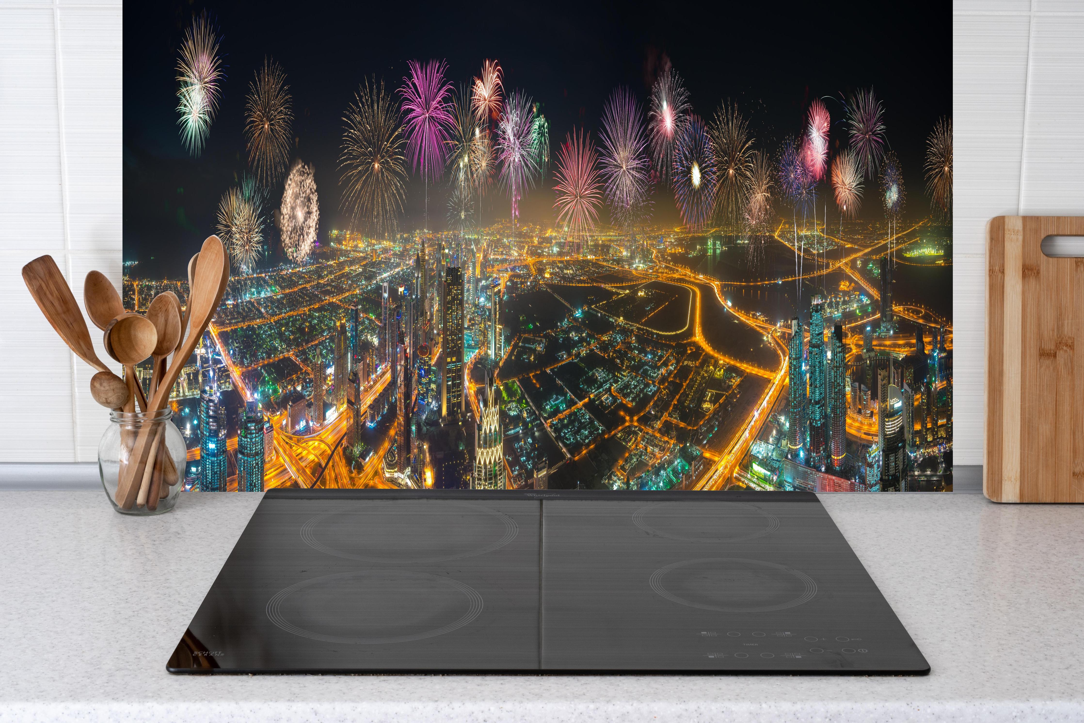 Küche - Spektakuläre Dubai Skyline mit Feuerwerk hinter weißen Hochglanz-Küchenregalen und schwarzem Wasserhahn