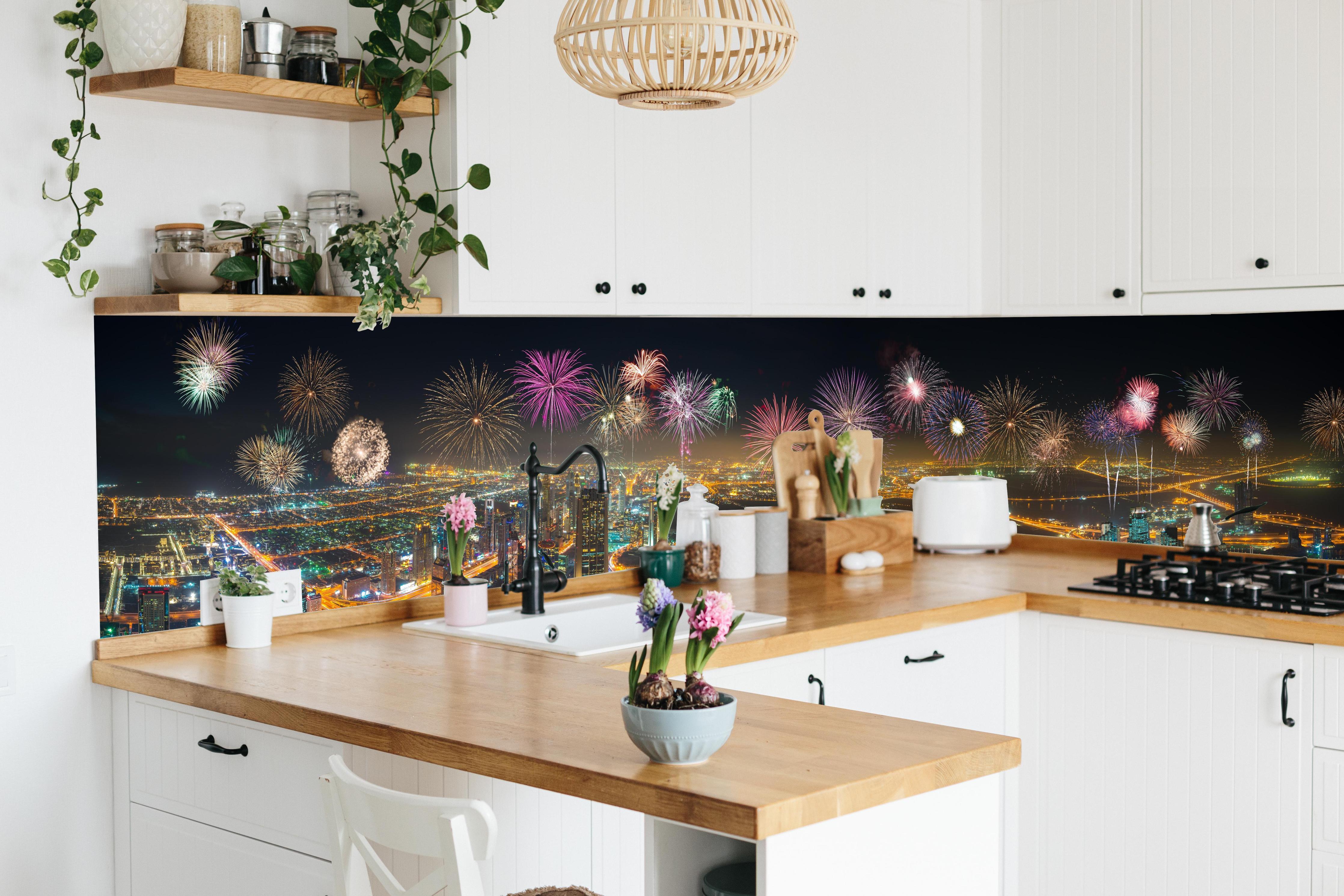 Küche - Spektakuläre Dubai Skyline mit Feuerwerk hinter weißen Hochglanz-Küchenregalen und schwarzem Wasserhahn