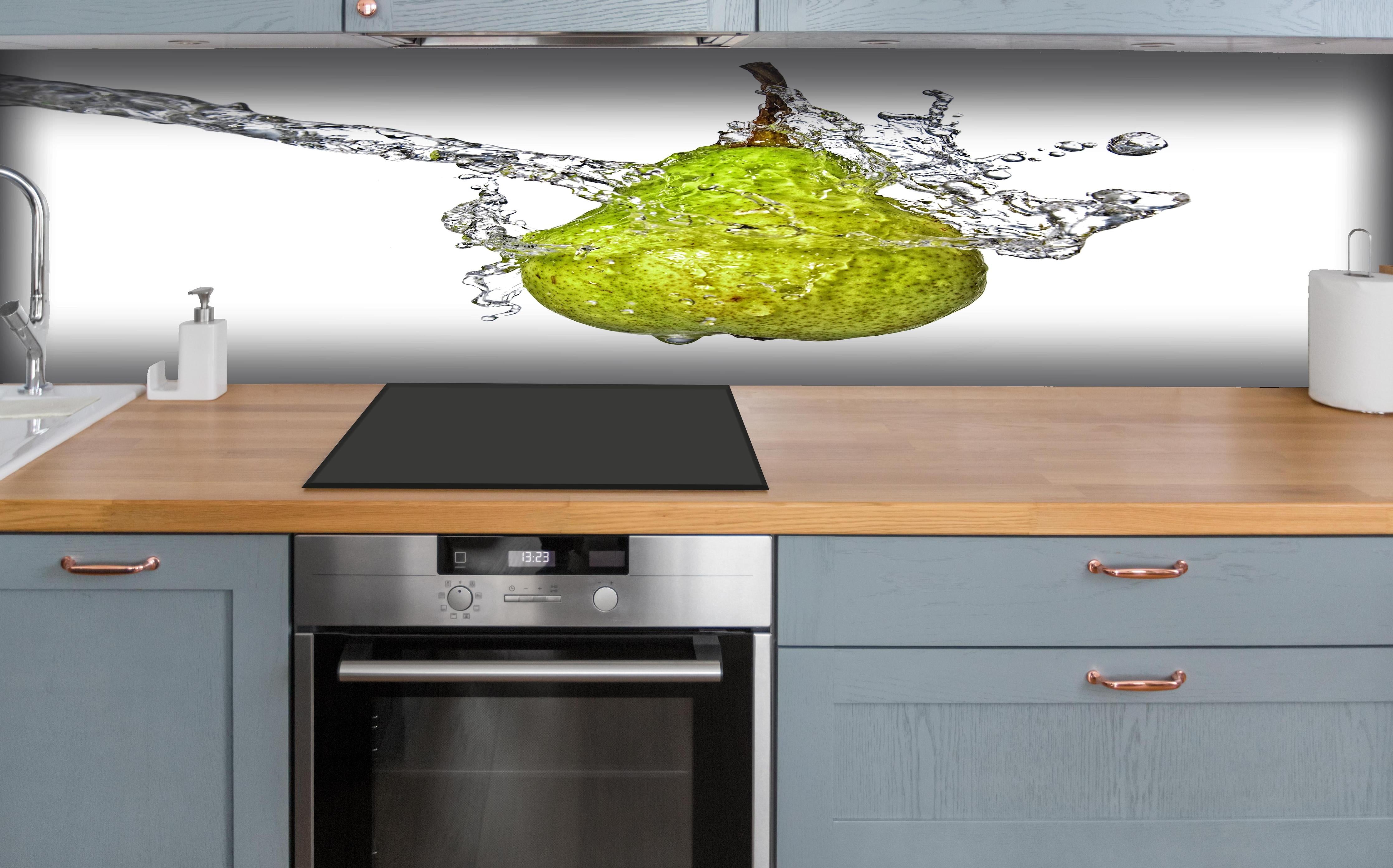 Küche - Spritzige Birne hinter weißen Hochglanz-Küchenregalen und schwarzem Wasserhahn