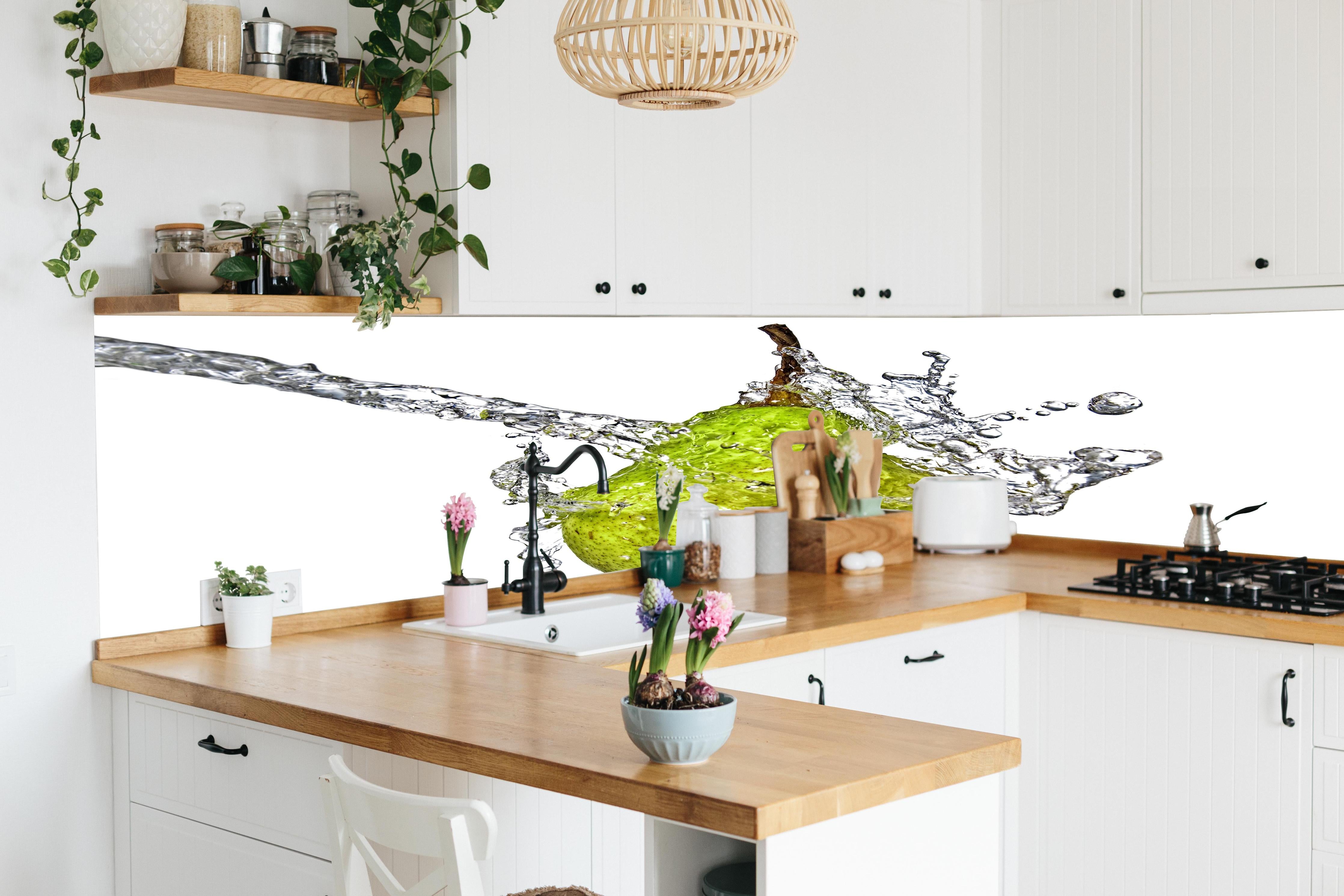 Küche - Spritzige Birne hinter weißen Hochglanz-Küchenregalen und schwarzem Wasserhahn