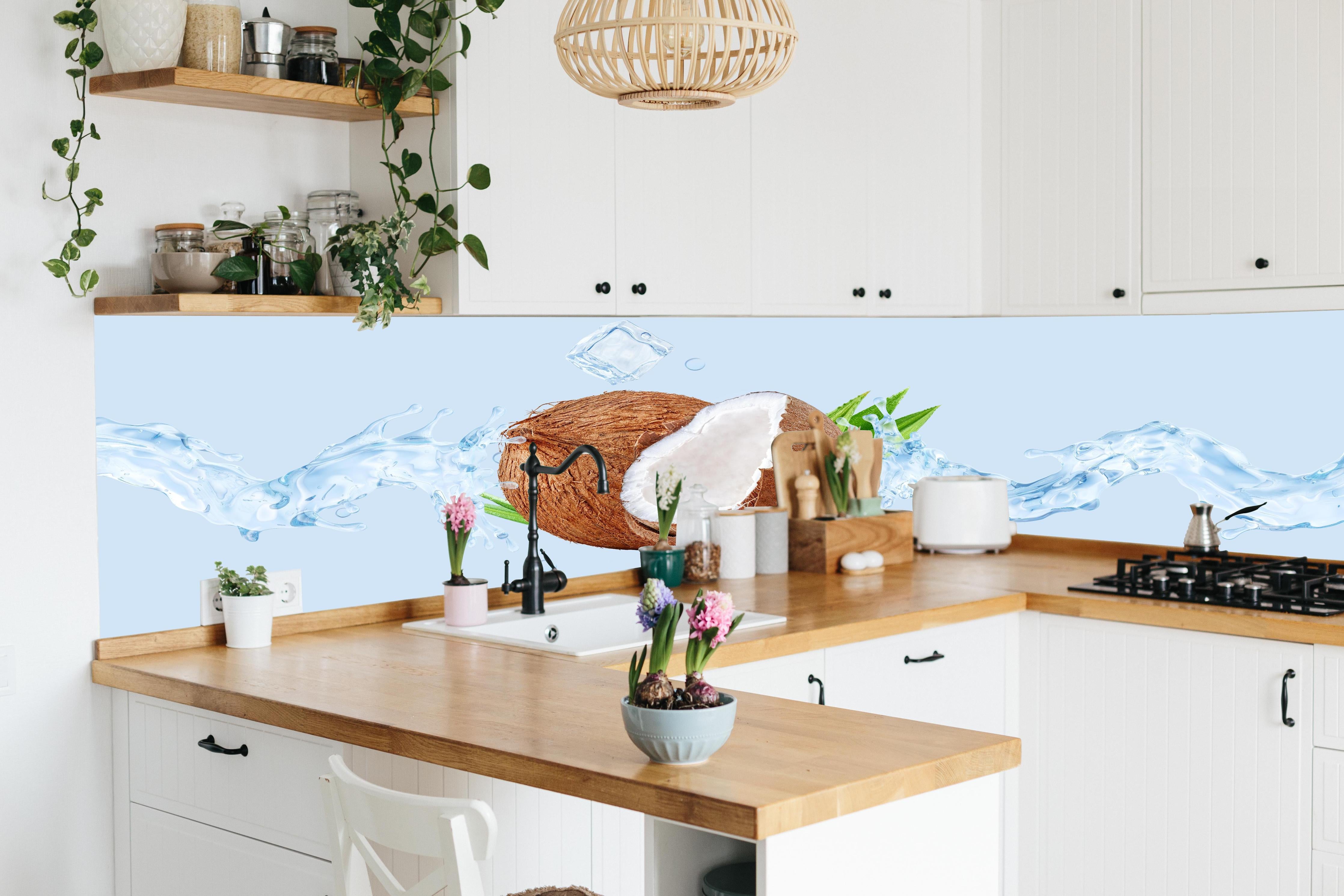 Küche - Spritzige Kokosnüsse hinter weißen Hochglanz-Küchenregalen und schwarzem Wasserhahn