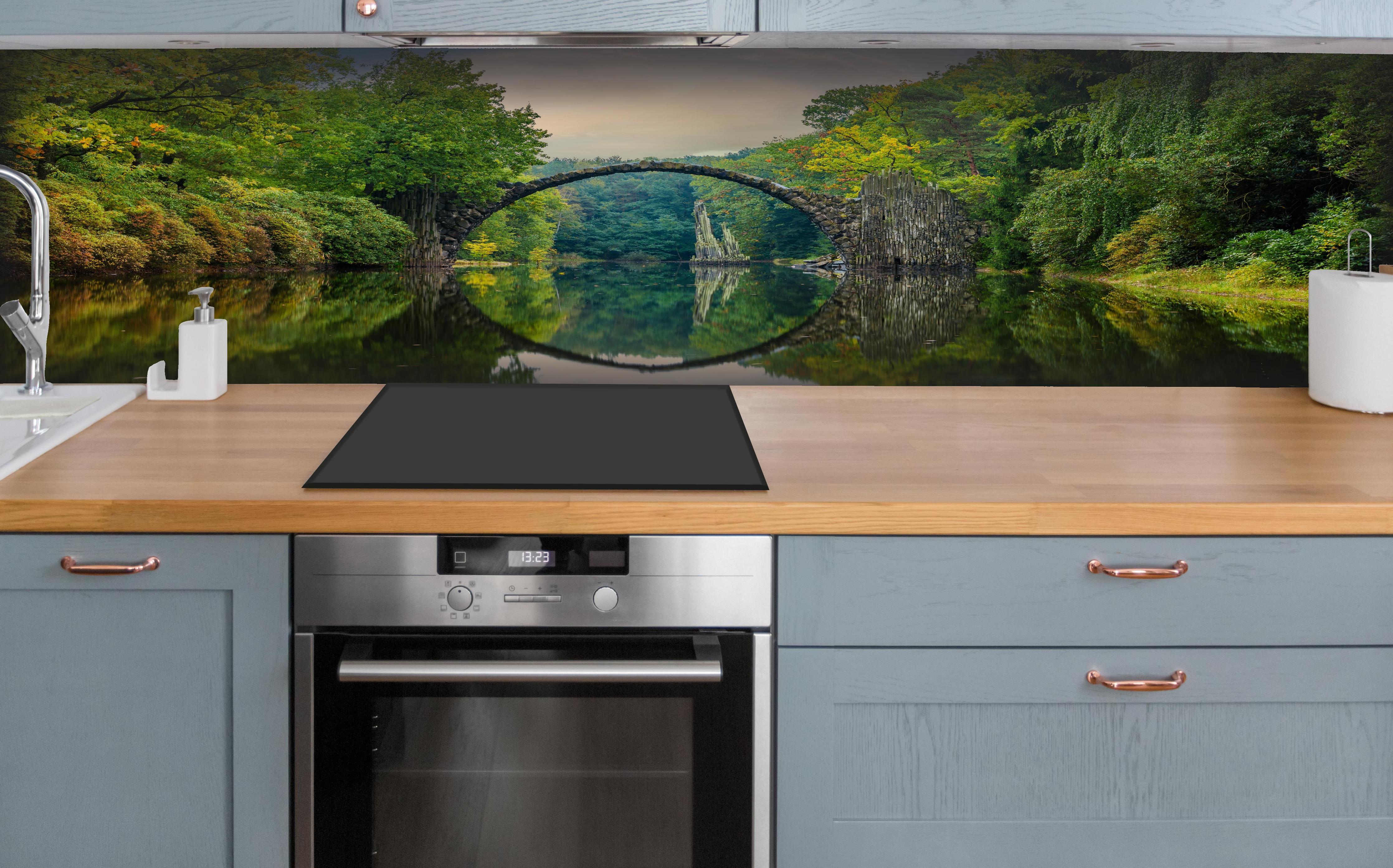 Küche - Steinbrücke über Fluss im Wald hinter weißen Hochglanz-Küchenregalen und schwarzem Wasserhahn