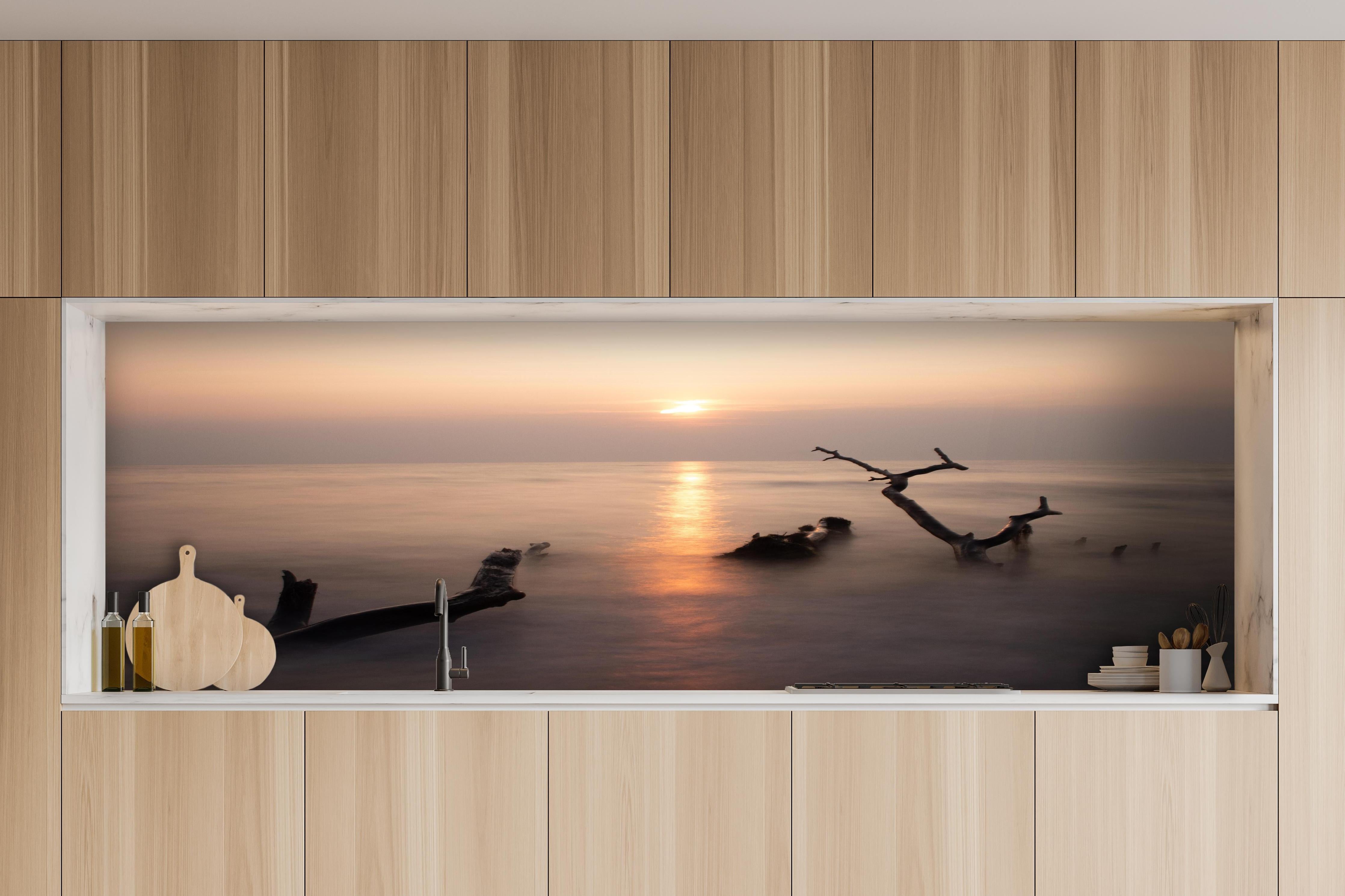 Küche - Stimmungsvoller Sonnenuntergangs-Strand hinter weißen Hochglanz-Küchenregalen und schwarzem Wasserhahn