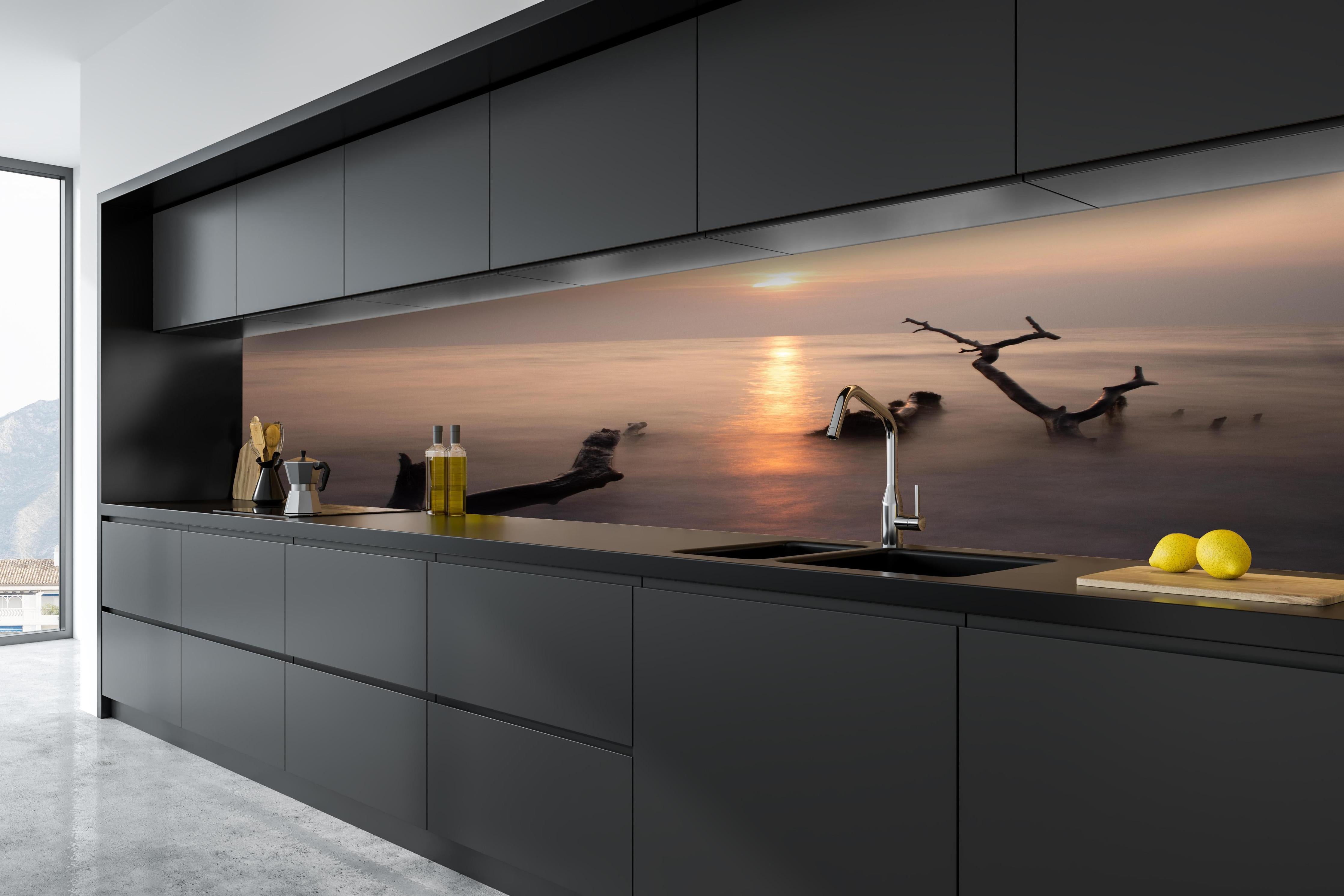 Küche - Stimmungsvoller Sonnenuntergangs-Strand hinter weißen Hochglanz-Küchenregalen und schwarzem Wasserhahn