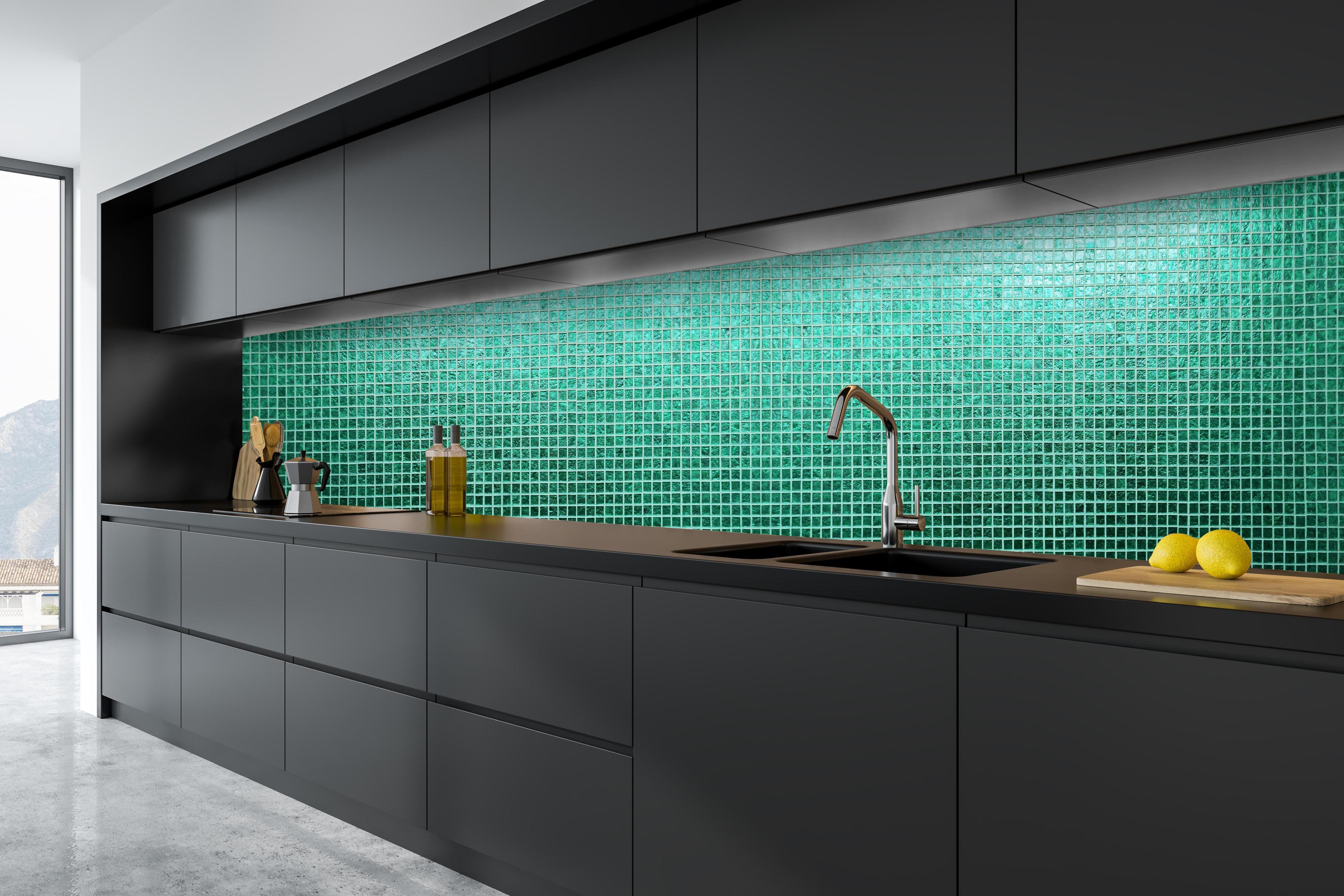 Küche - Strukturierte grüne Fliesenmosaik Textur hinter weißen Hochglanz-Küchenregalen und schwarzem Wasserhahn