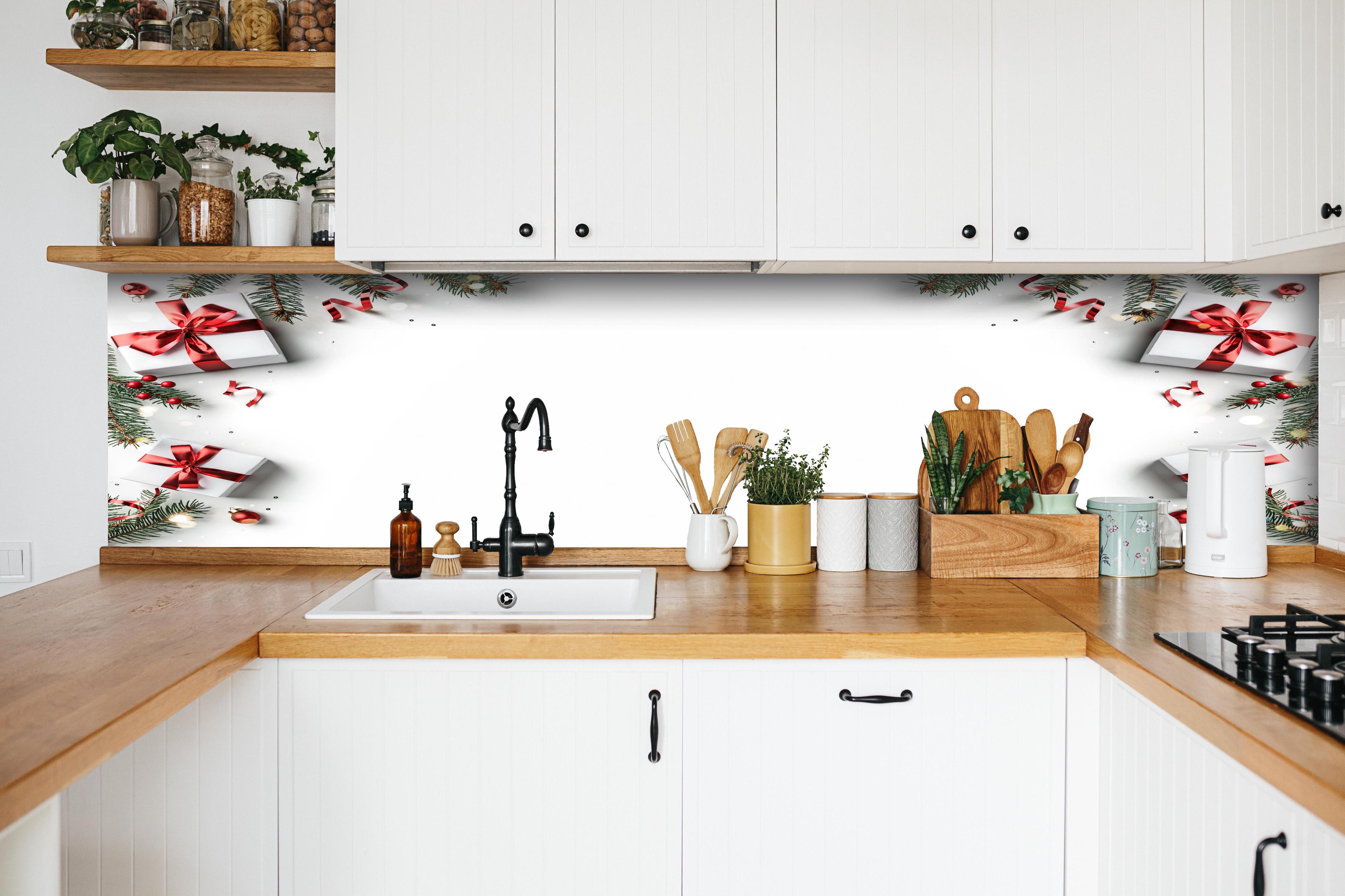 Küche - Tannenzweige als Rahmen hinter weißen Hochglanz-Küchenregalen und schwarzem Wasserhahn