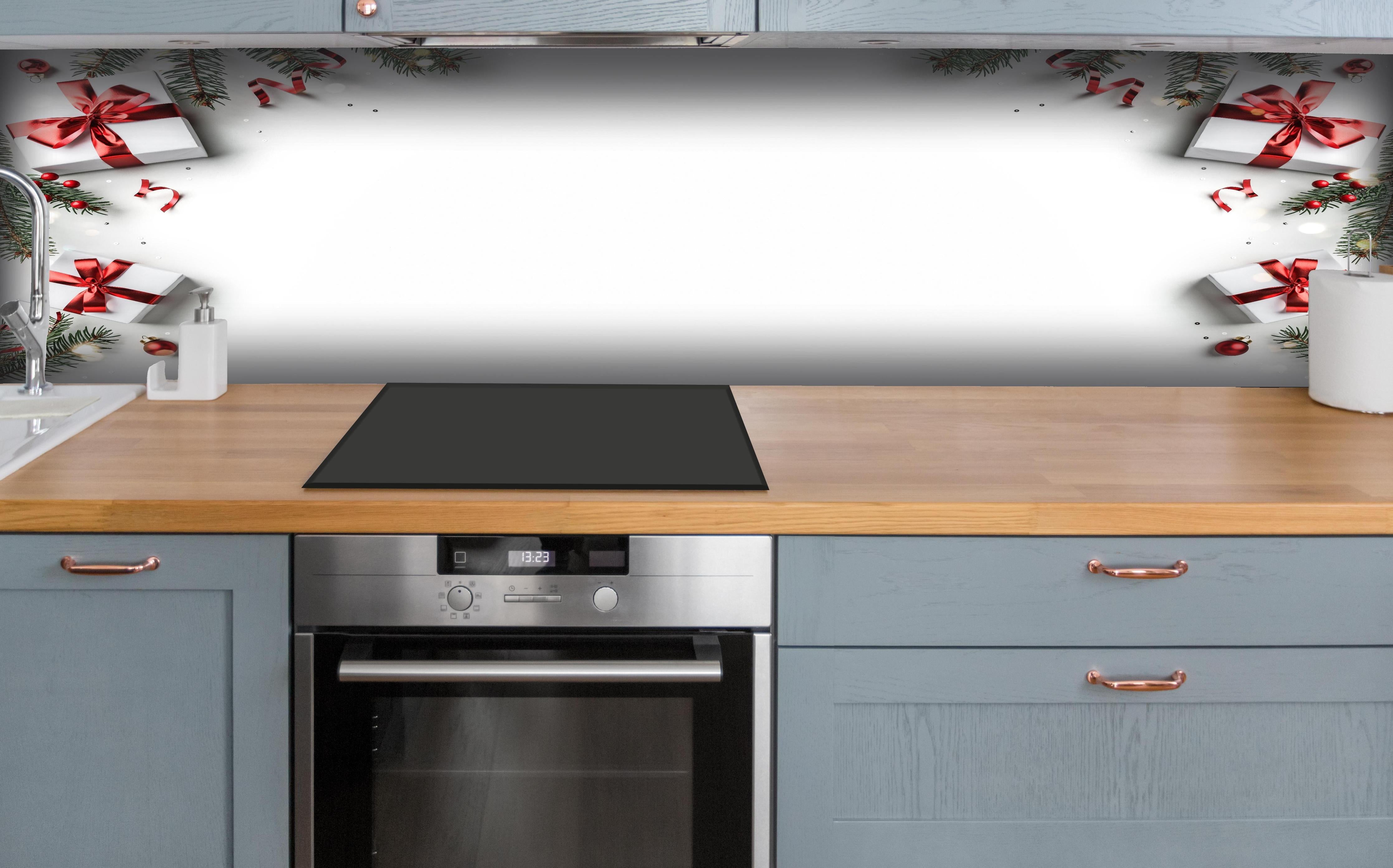 Küche - Tannenzweige als Rahmen hinter weißen Hochglanz-Küchenregalen und schwarzem Wasserhahn