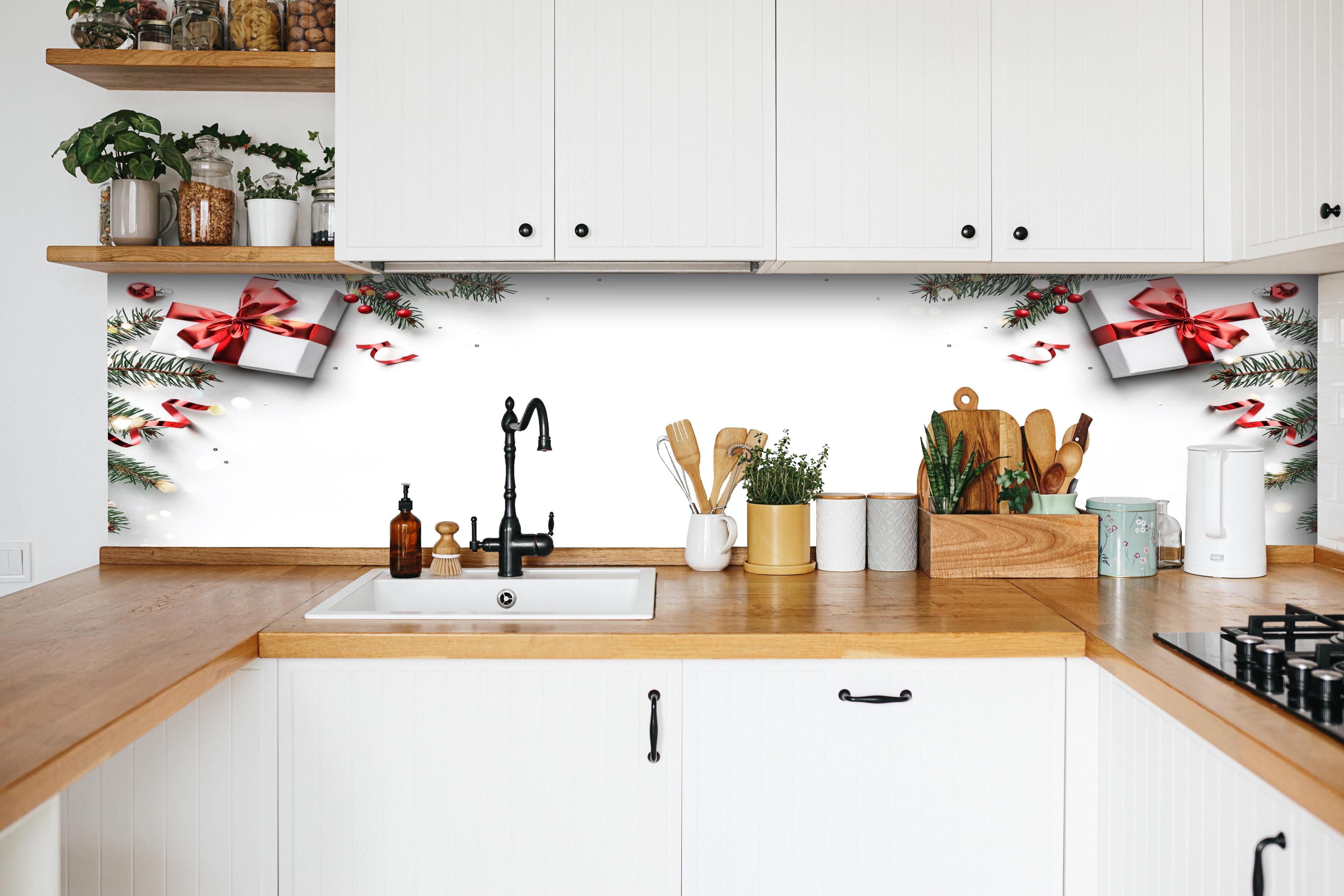 Küche - Tannenzweige auf weißem Hintergrund hinter weißen Hochglanz-Küchenregalen und schwarzem Wasserhahn