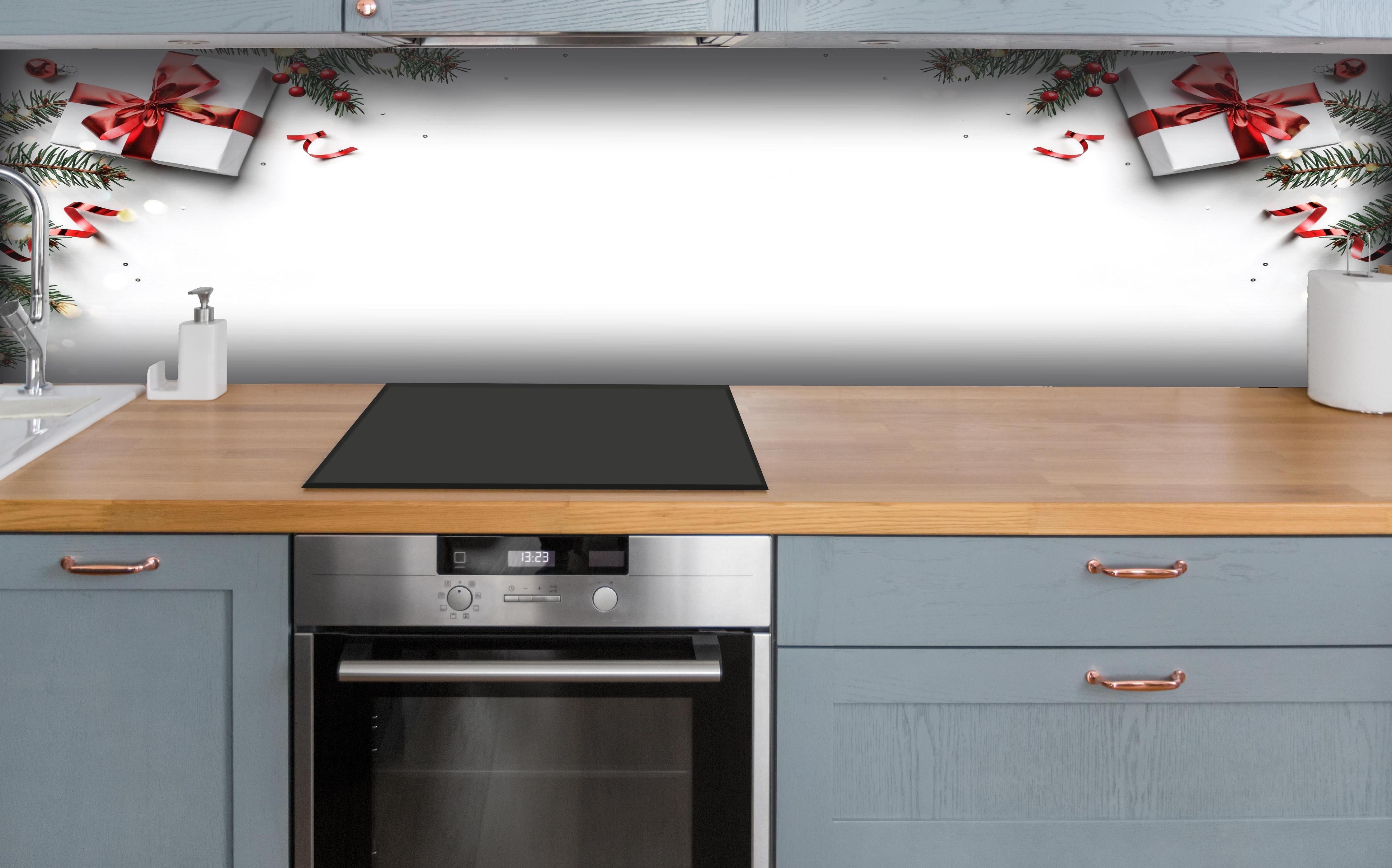 Küche - Tannenzweige auf weißem Hintergrund hinter weißen Hochglanz-Küchenregalen und schwarzem Wasserhahn