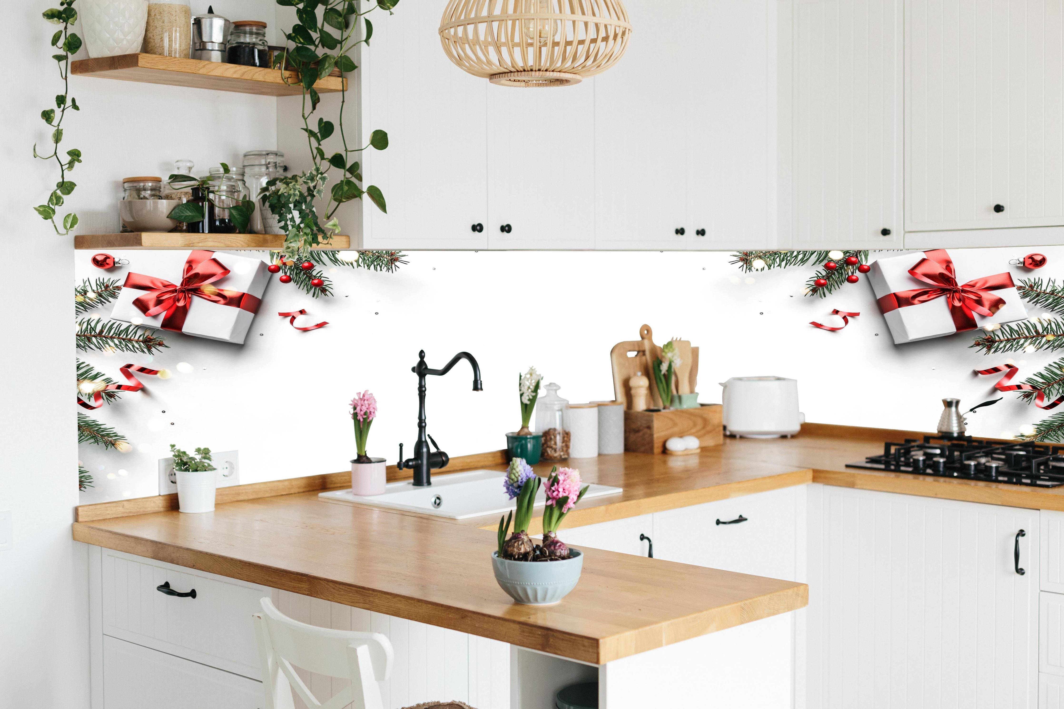 Küche - Tannenzweige auf weißem Hintergrund hinter weißen Hochglanz-Küchenregalen und schwarzem Wasserhahn