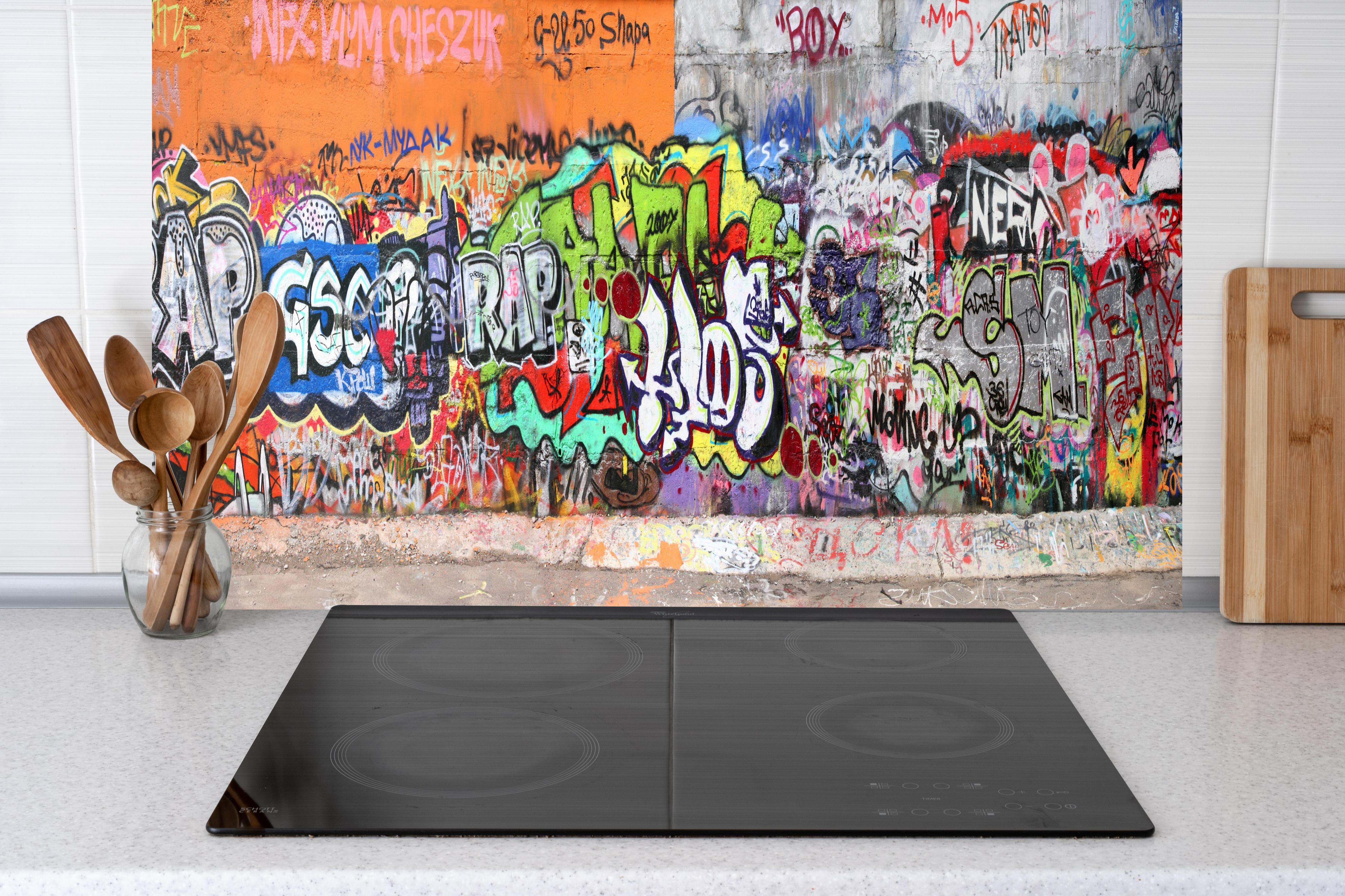 Küche - Textur Urbaner Graffiti-Art Streetstyle hinter weißen Hochglanz-Küchenregalen und schwarzem Wasserhahn