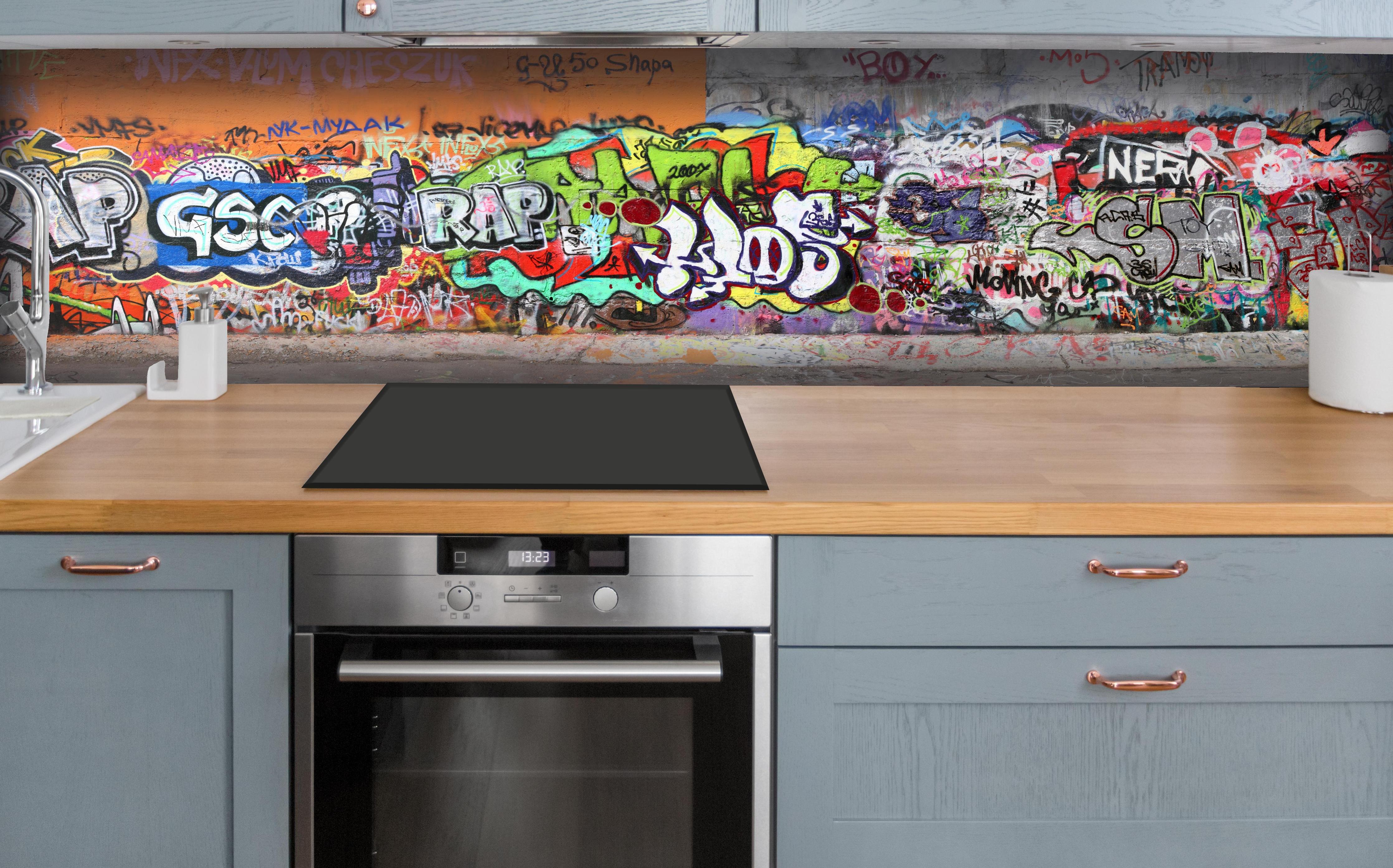 Küche - Textur Urbaner Graffiti-Art Streetstyle hinter weißen Hochglanz-Küchenregalen und schwarzem Wasserhahn