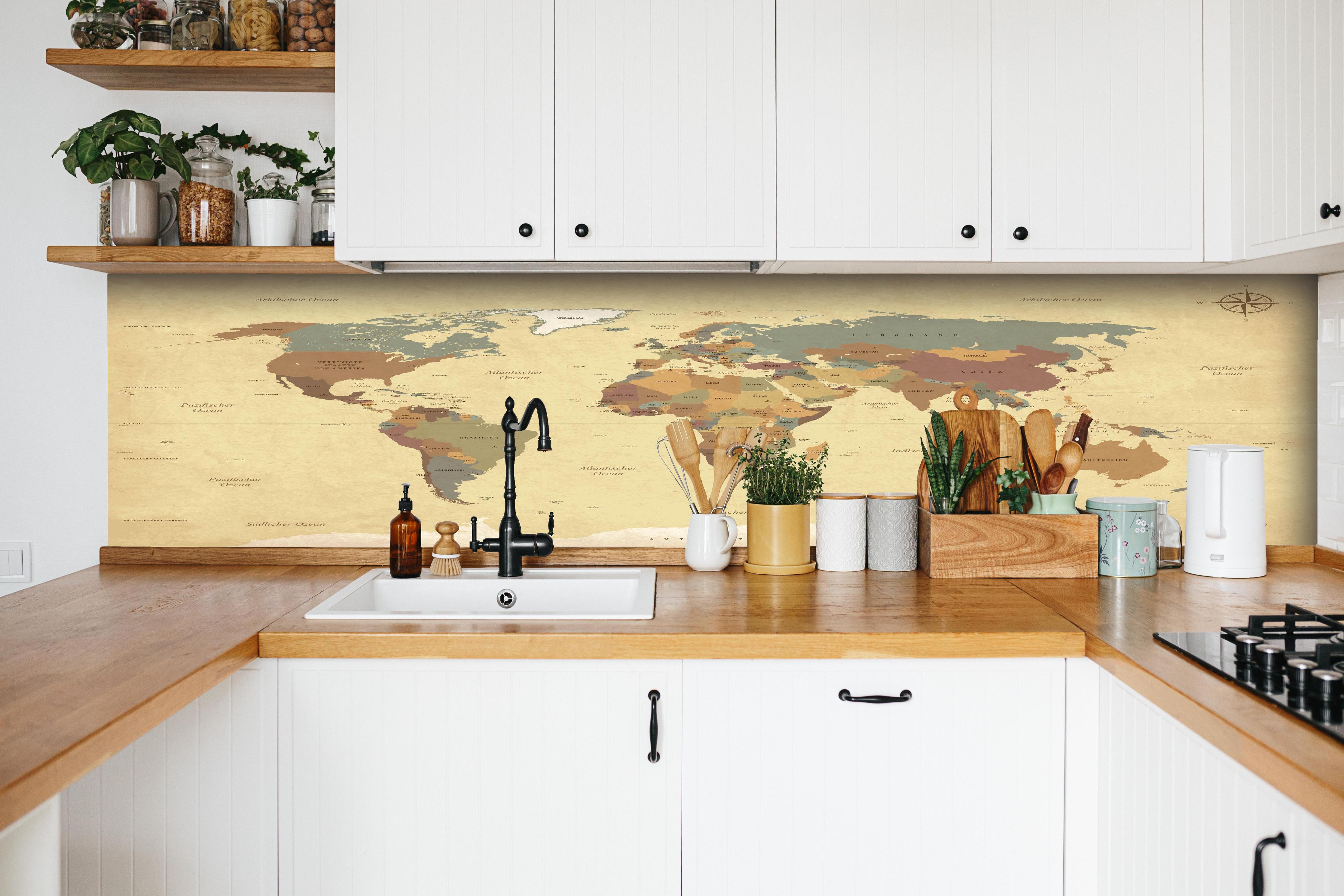 Küche - Texturierte Vintage Weltkarte in Beigetönen hinter weißen Hochglanz-Küchenregalen und schwarzem Wasserhahn