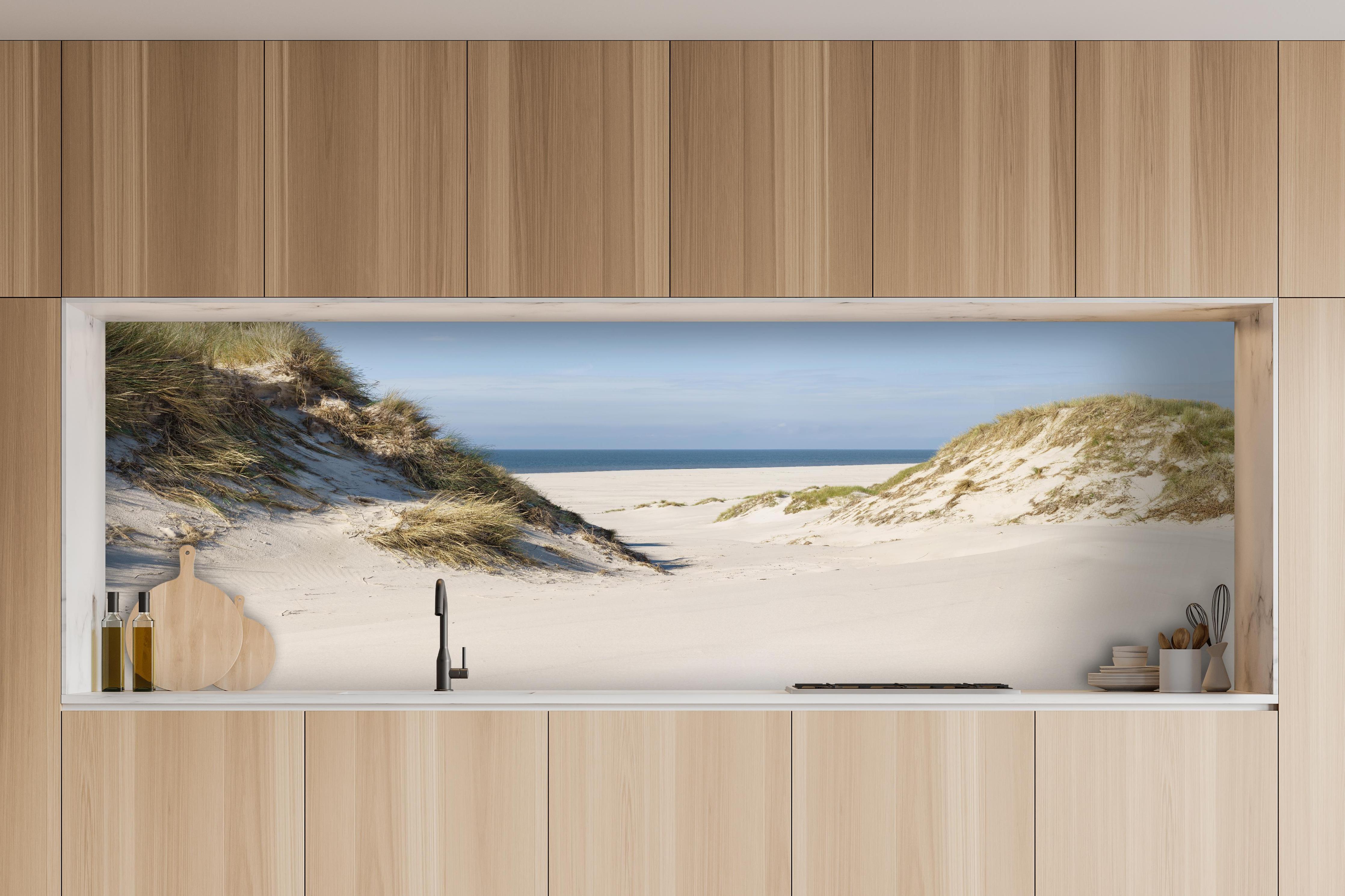 Küche - Traumhafte Sanddüne mit Blick auf das ruhige blaue Meer hinter weißen Hochglanz-Küchenregalen und schwarzem Wasserhahn