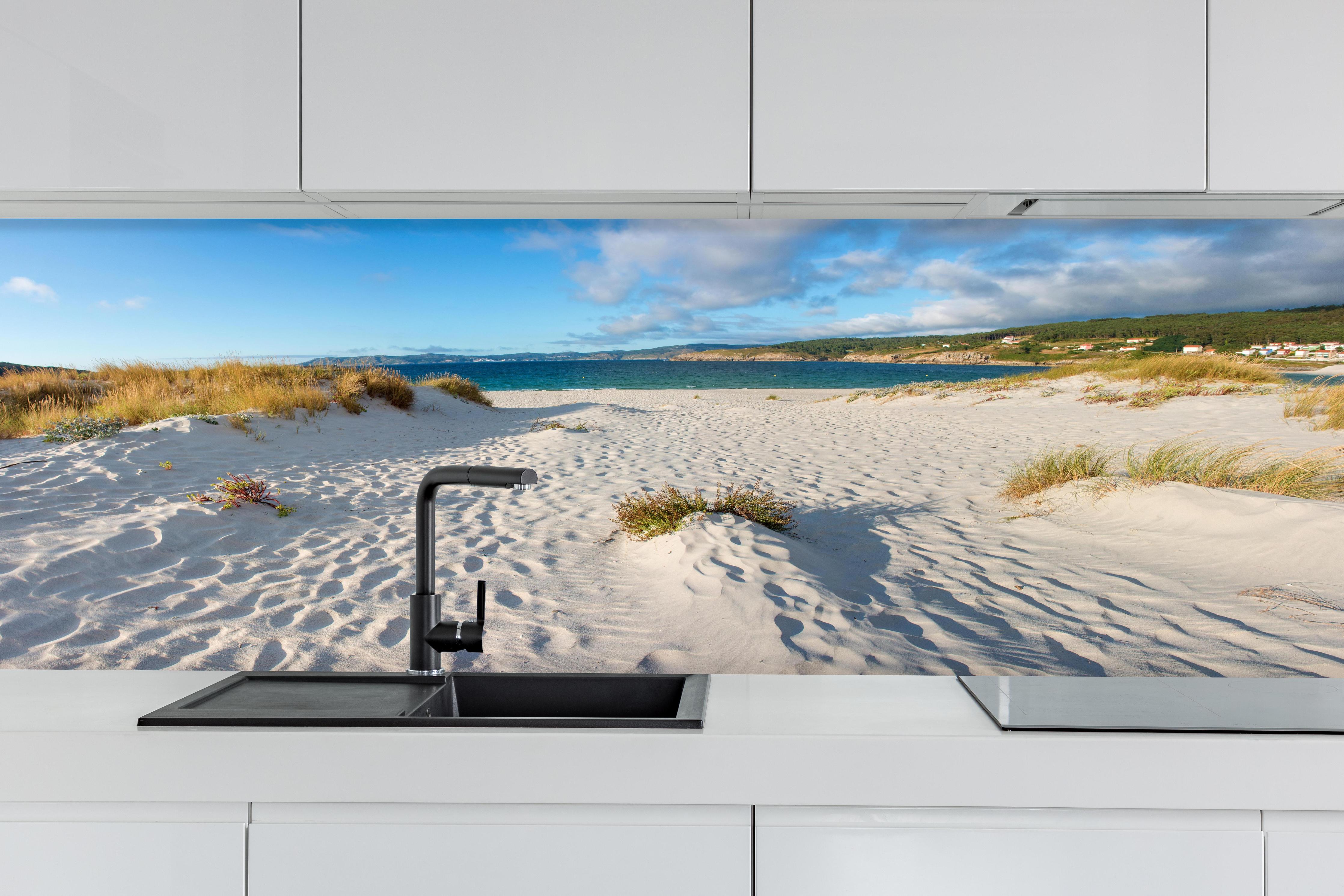 Küche - Traumhafte weiße Sanddünen mit sanftem Blau des Meeres und Himmel hinter weißen Hochglanz-Küchenregalen und schwarzem Wasserhahn