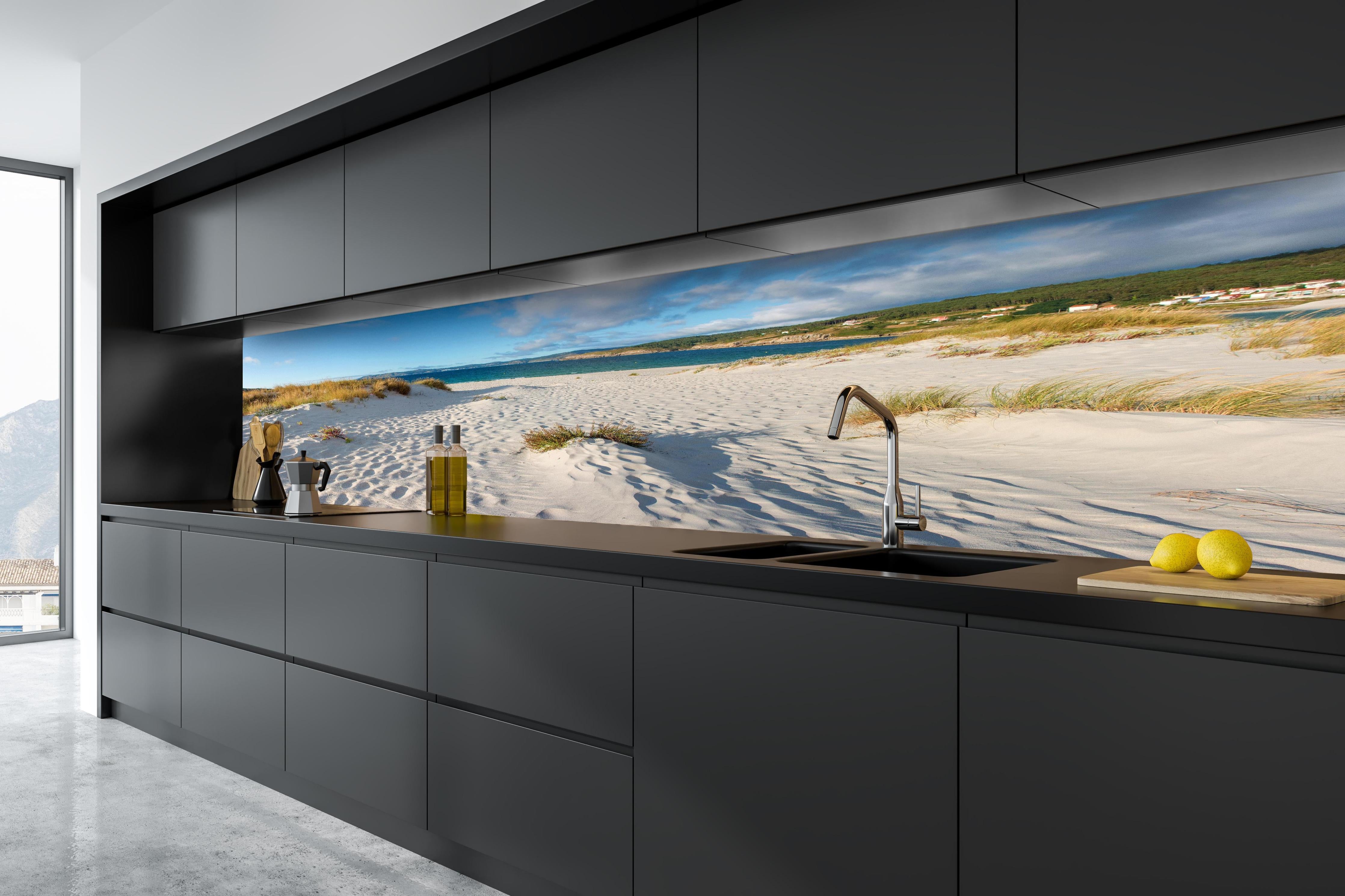 Küche - Traumhafte weiße Sanddünen mit sanftem Blau des Meeres und Himmel hinter weißen Hochglanz-Küchenregalen und schwarzem Wasserhahn