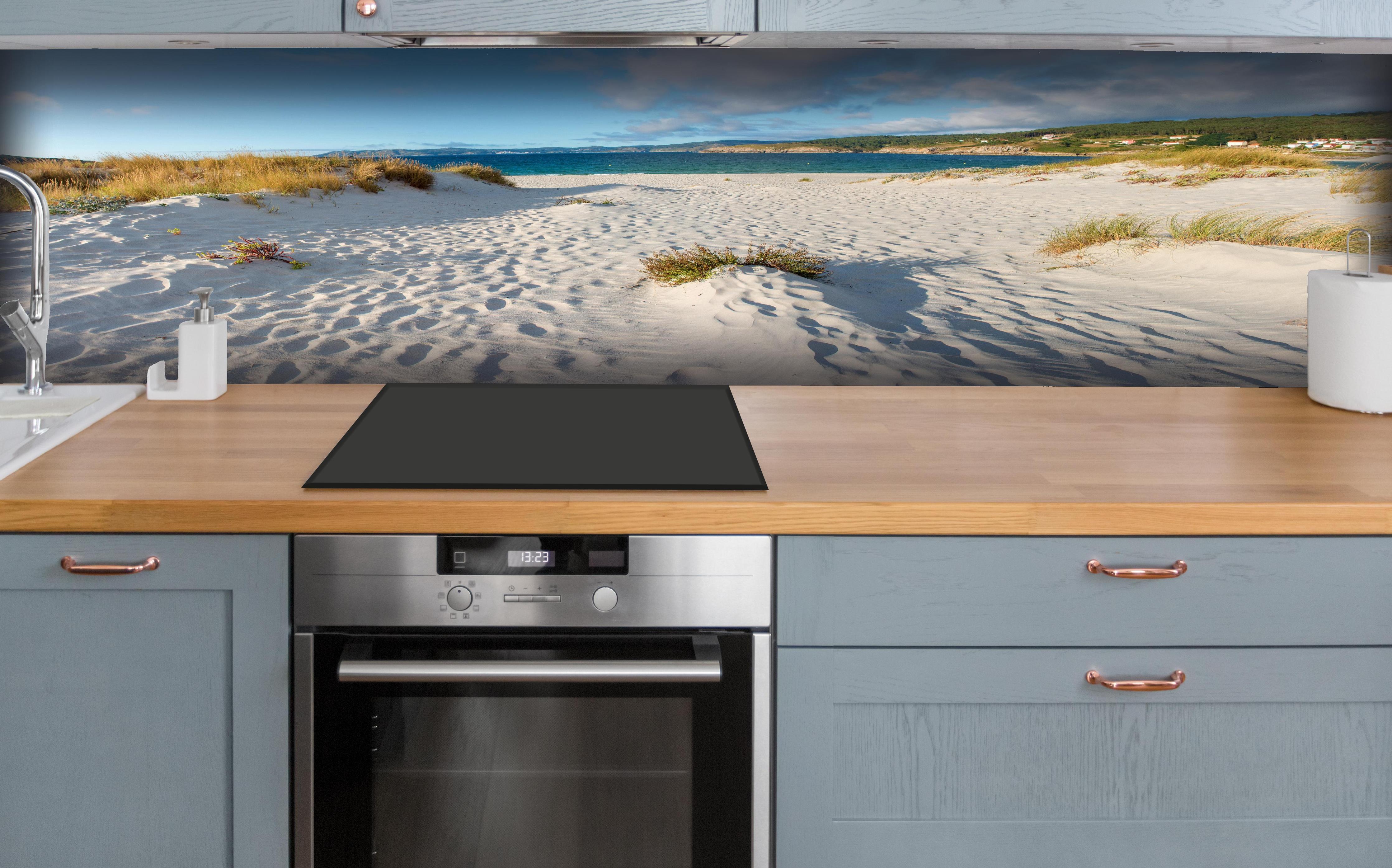 Küche - Traumhafte weiße Sanddünen mit sanftem Blau des Meeres und Himmel hinter weißen Hochglanz-Küchenregalen und schwarzem Wasserhahn