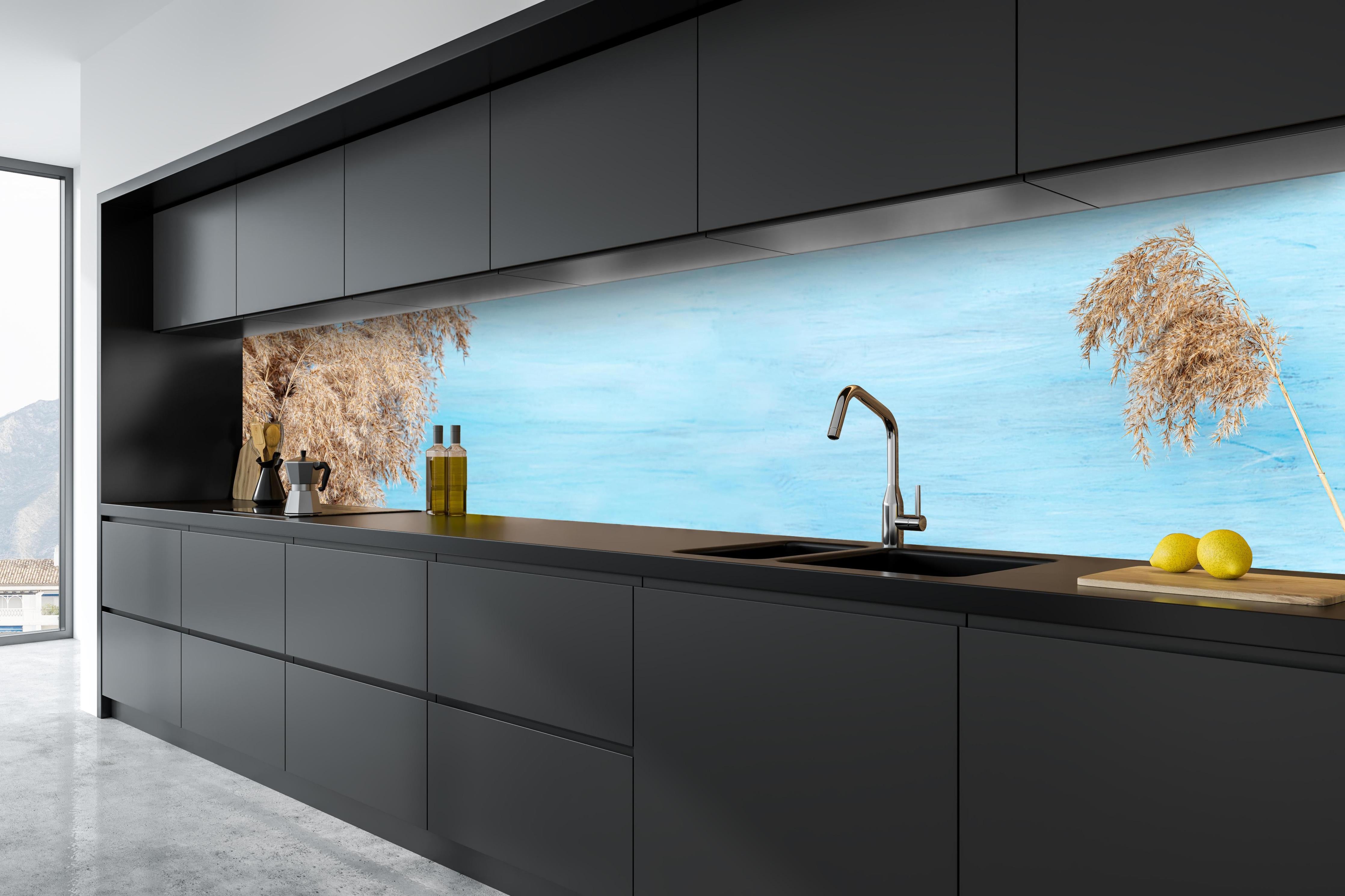 Küche - Trockene Pflanzen über dem Meer hinter weißen Hochglanz-Küchenregalen und schwarzem Wasserhahn