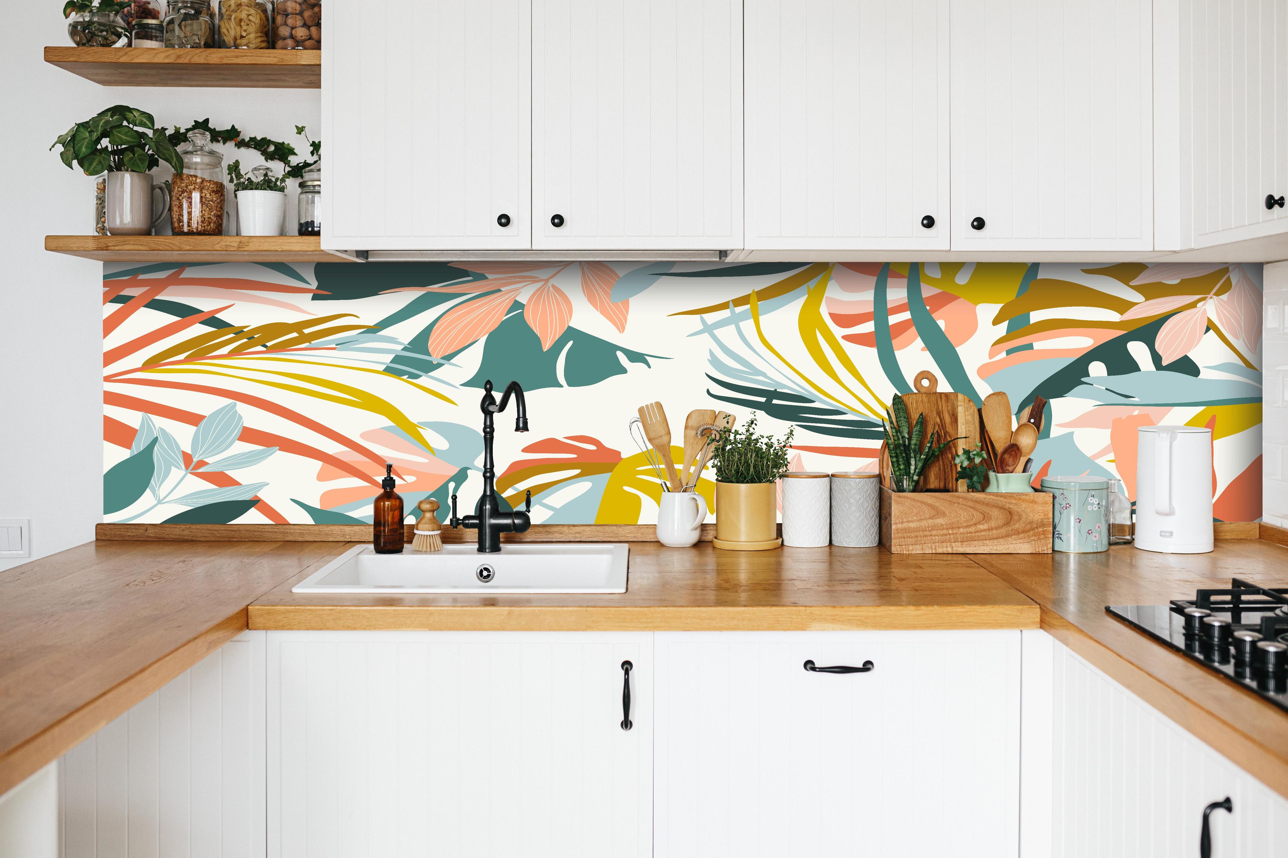 Küche - Tropische Blätter Pastellfarben Illustration hinter weißen Hochglanz-Küchenregalen und schwarzem Wasserhahn