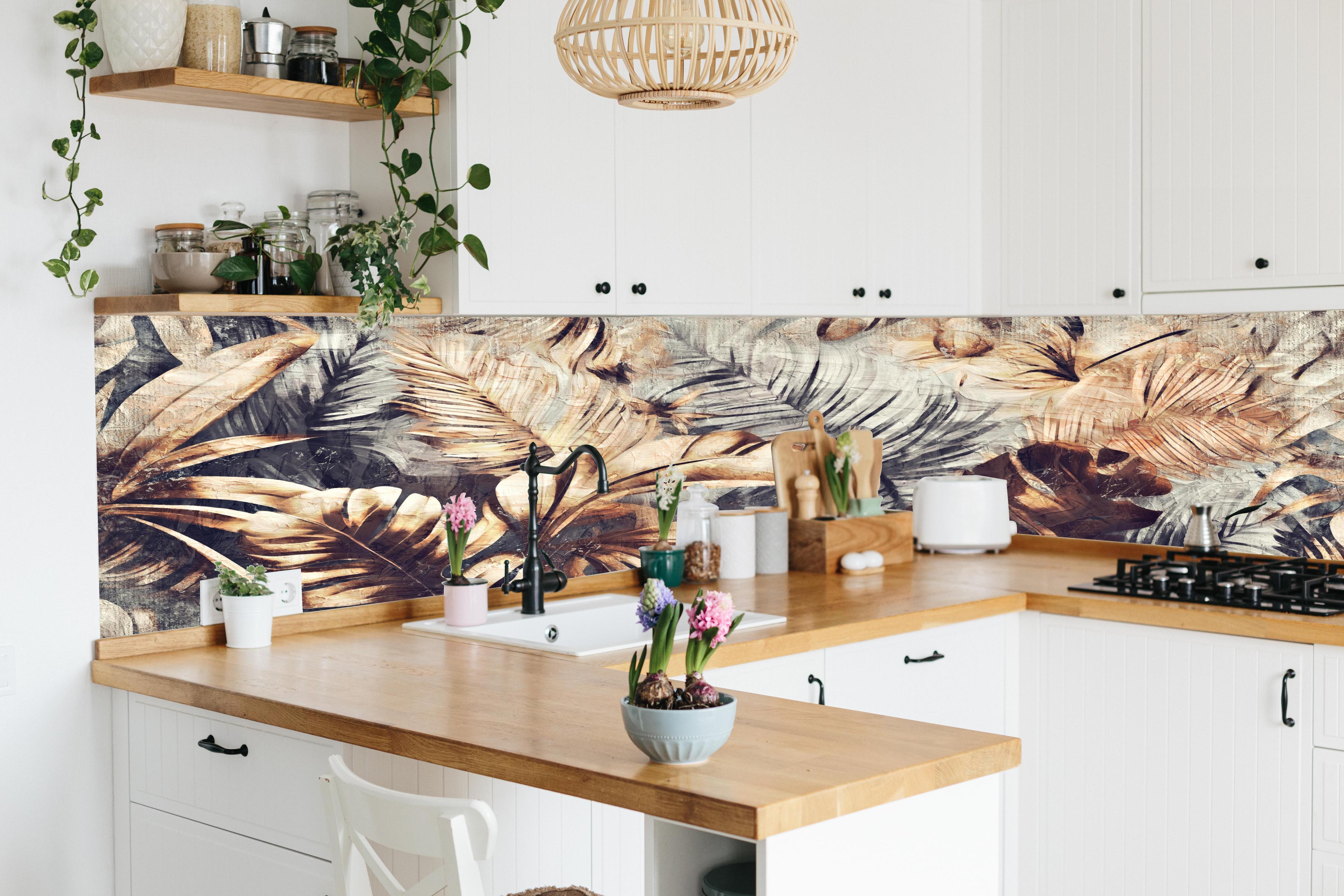 Küche - Tropische Palmenblätter in Gelb-Braun hinter weißen Hochglanz-Küchenregalen und schwarzem Wasserhahn