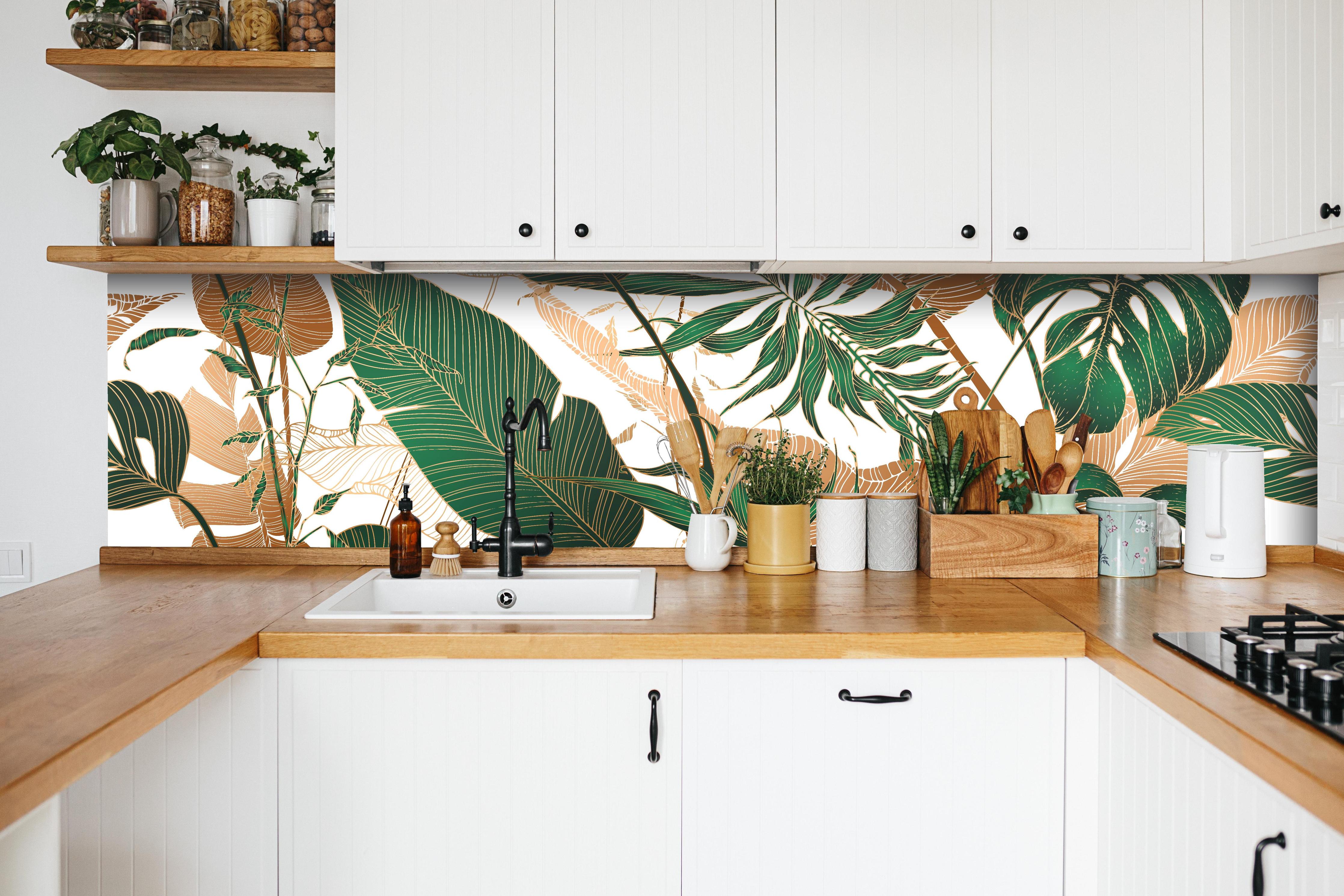 Küche - Tropisches Blattmuster Grün-Beige hinter weißen Hochglanz-Küchenregalen und schwarzem Wasserhahn