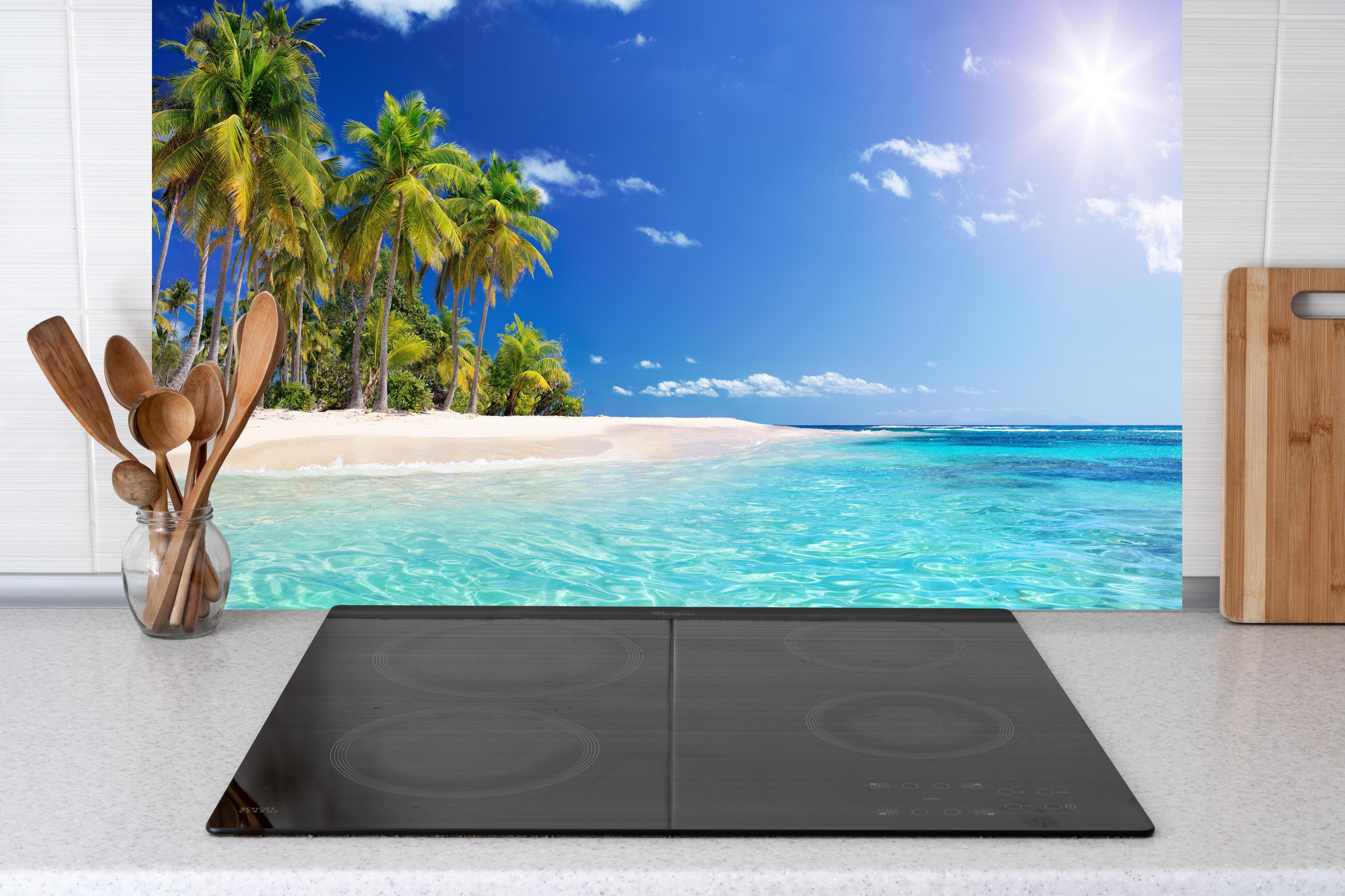 Küche - Tropisches Paradies mit strahlend blauem Himmel und palmenumsäumtem Strand hinter weißen Hochglanz-Küchenregalen und schwarzem Wasserhahn