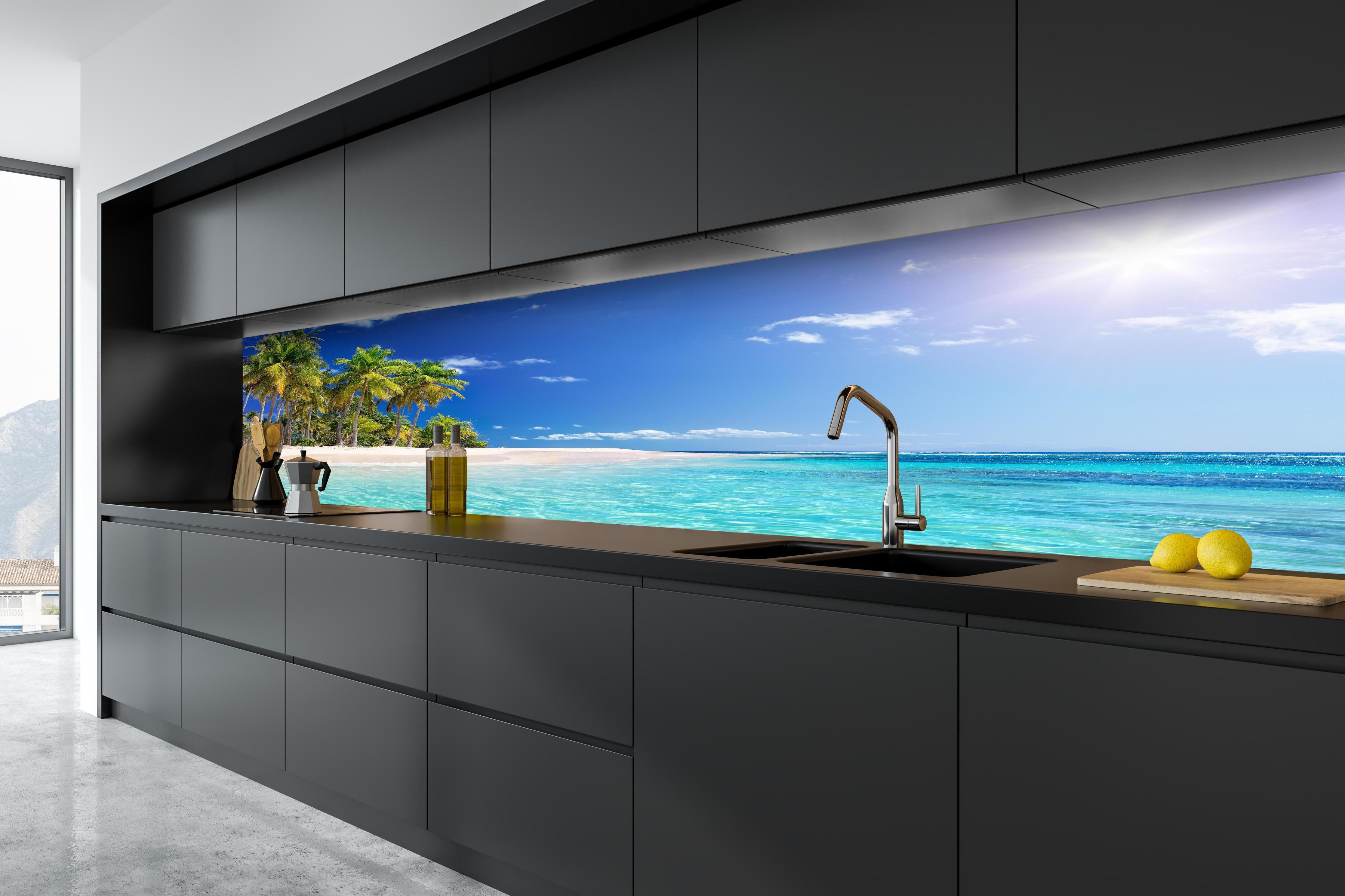 Küche - Tropisches Paradies mit strahlend blauem Himmel und palmenumsäumtem Strand hinter weißen Hochglanz-Küchenregalen und schwarzem Wasserhahn