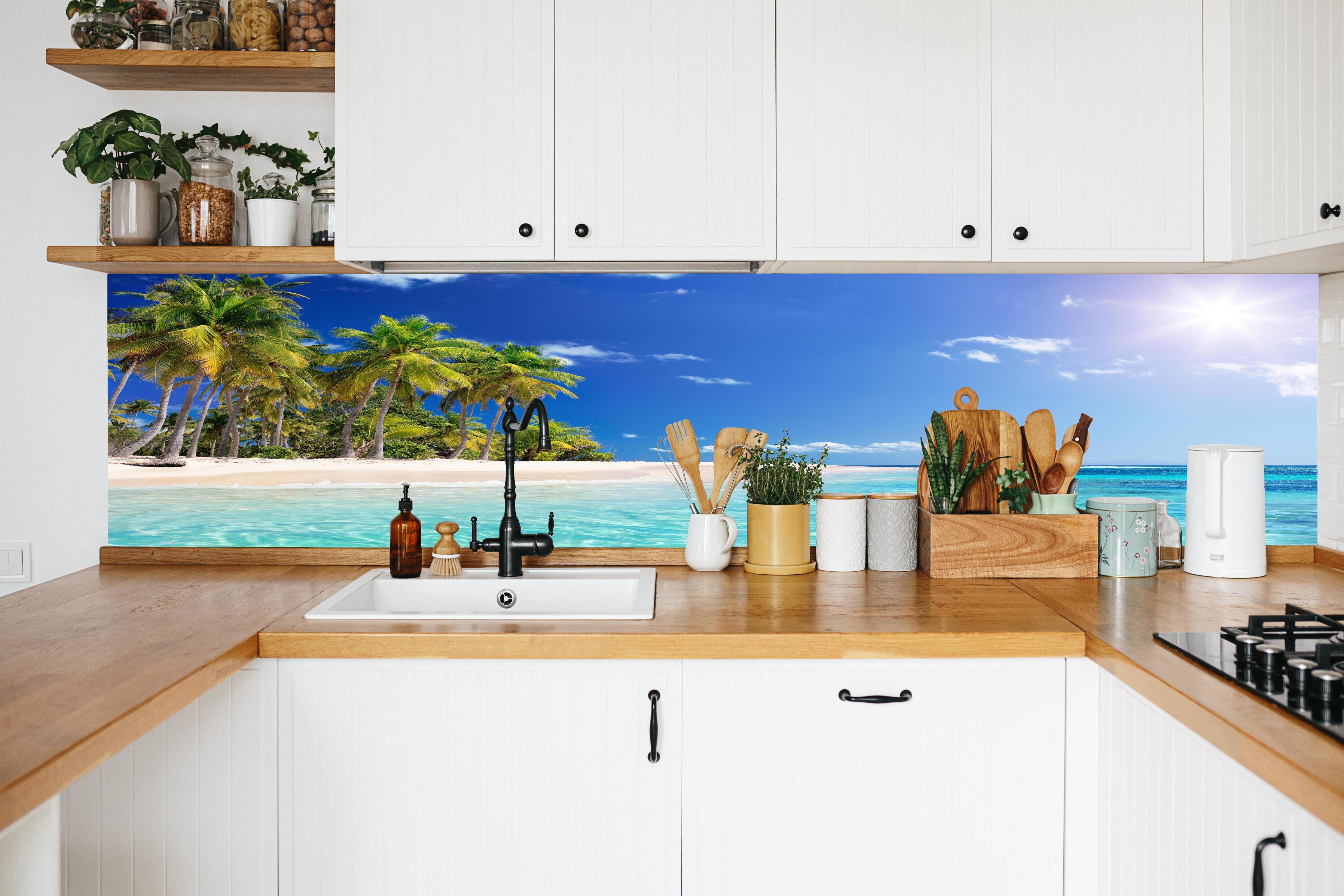 Küche - Tropisches Paradies mit strahlend blauem Himmel und palmenumsäumtem Strand hinter weißen Hochglanz-Küchenregalen und schwarzem Wasserhahn
