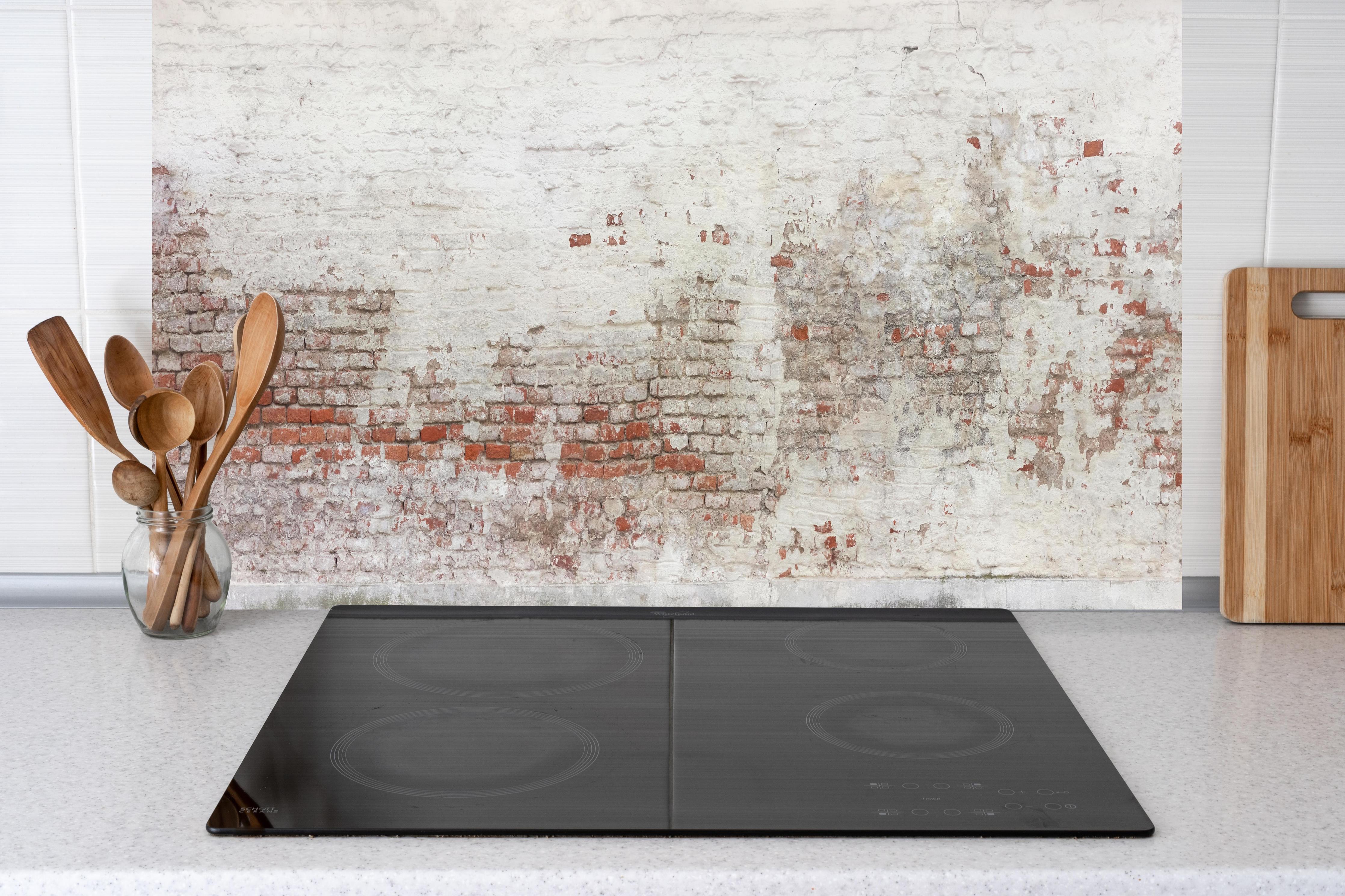 Küche - Veraltete Hauswand hinter weißen Hochglanz-Küchenregalen und schwarzem Wasserhahn