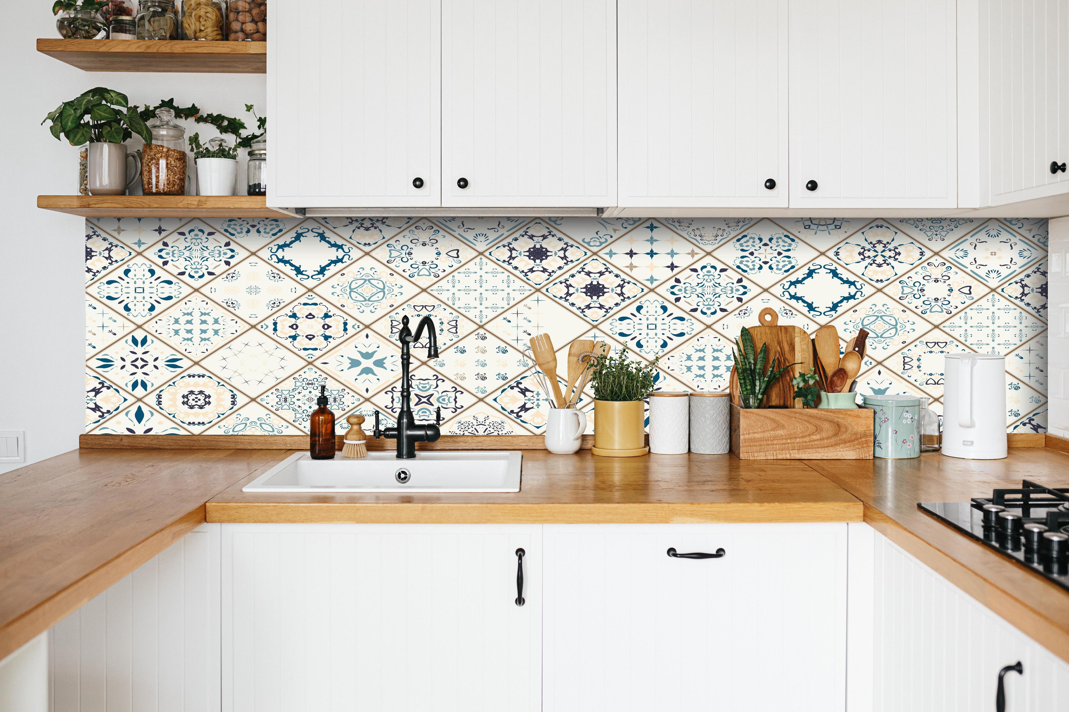 Küche - Vintage Fliesenmuster in Blau und Beige hinter weißen Hochglanz-Küchenregalen und schwarzem Wasserhahn