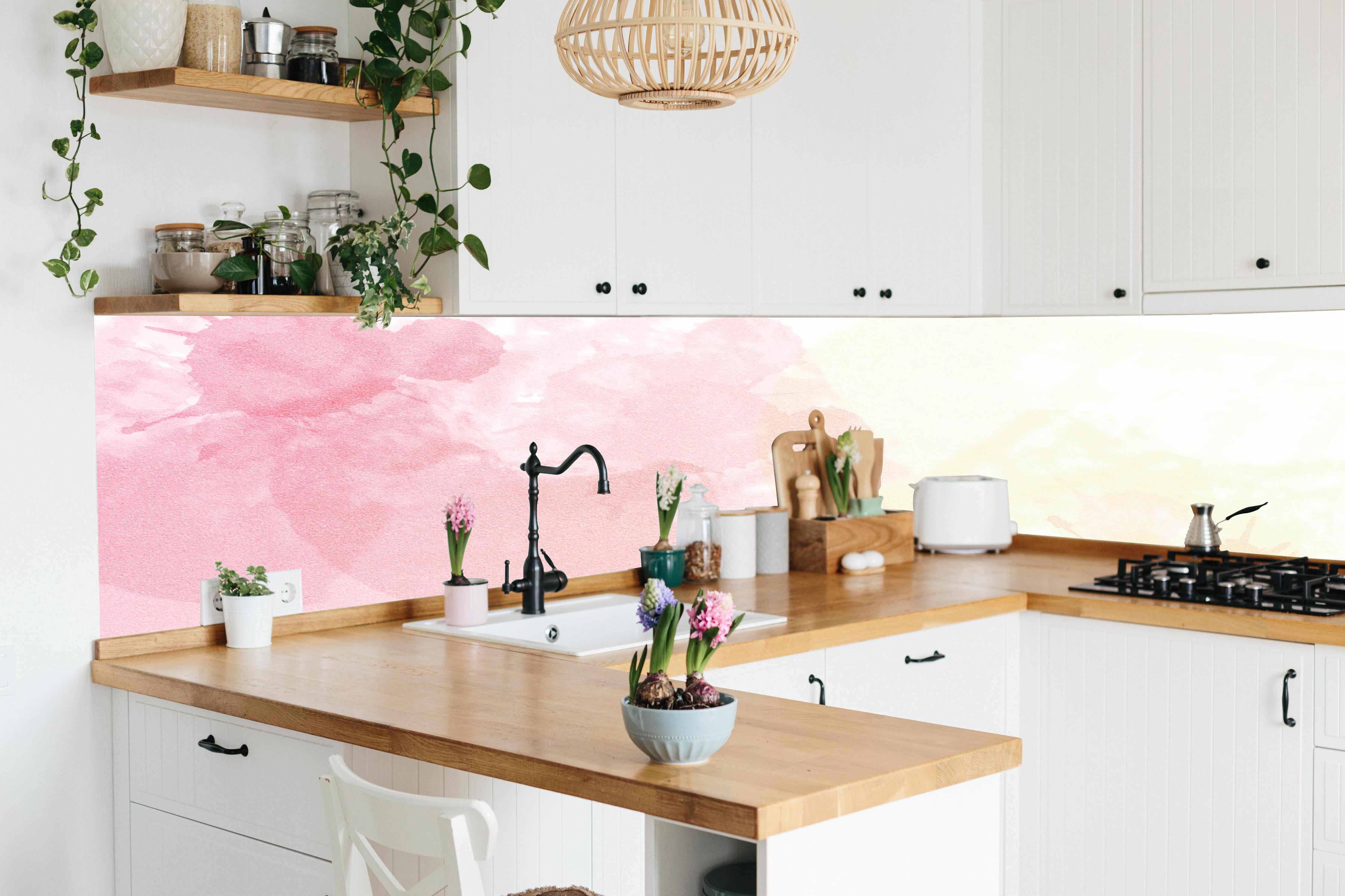 Küche - Weiche Rosé-Gelb-Aquarell Wandgestaltung hinter weißen Hochglanz-Küchenregalen und schwarzem Wasserhahn
