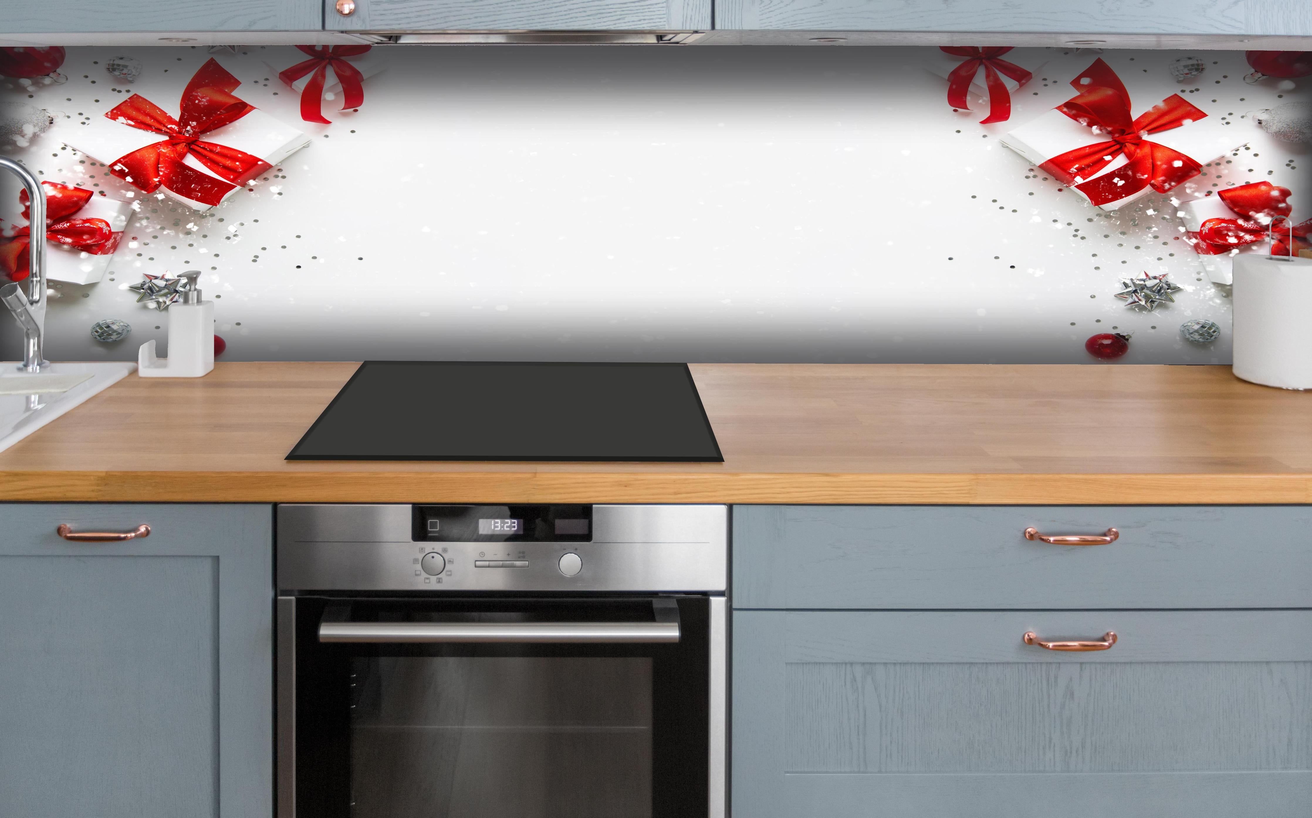 Küche - Weihnachtliche Geschenke mit Roter Schleife hinter weißen Hochglanz-Küchenregalen und schwarzem Wasserhahn