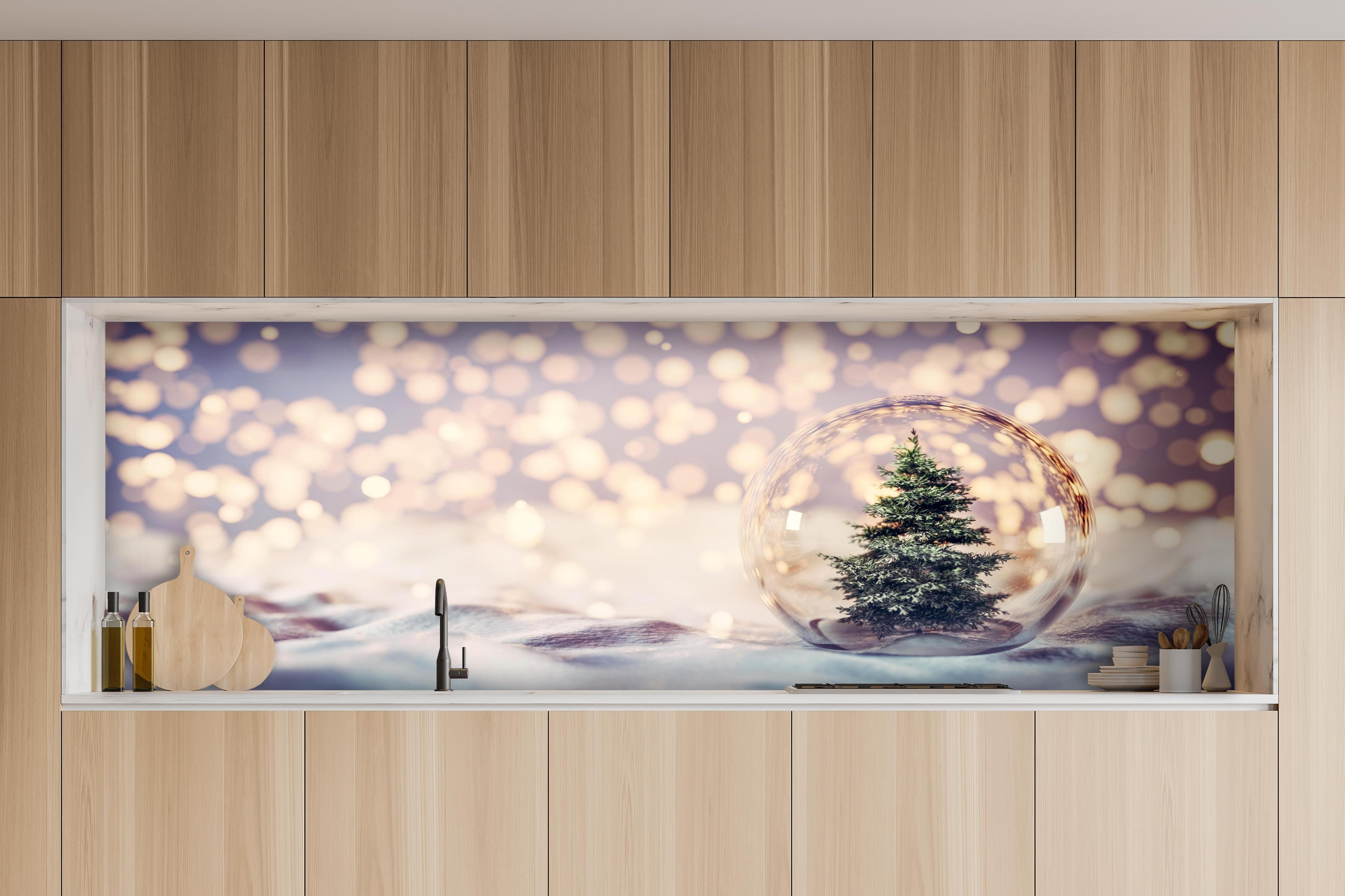 Küche - Weihnachtsbaum in einer Glaskugel hinter weißen Hochglanz-Küchenregalen und schwarzem Wasserhahn