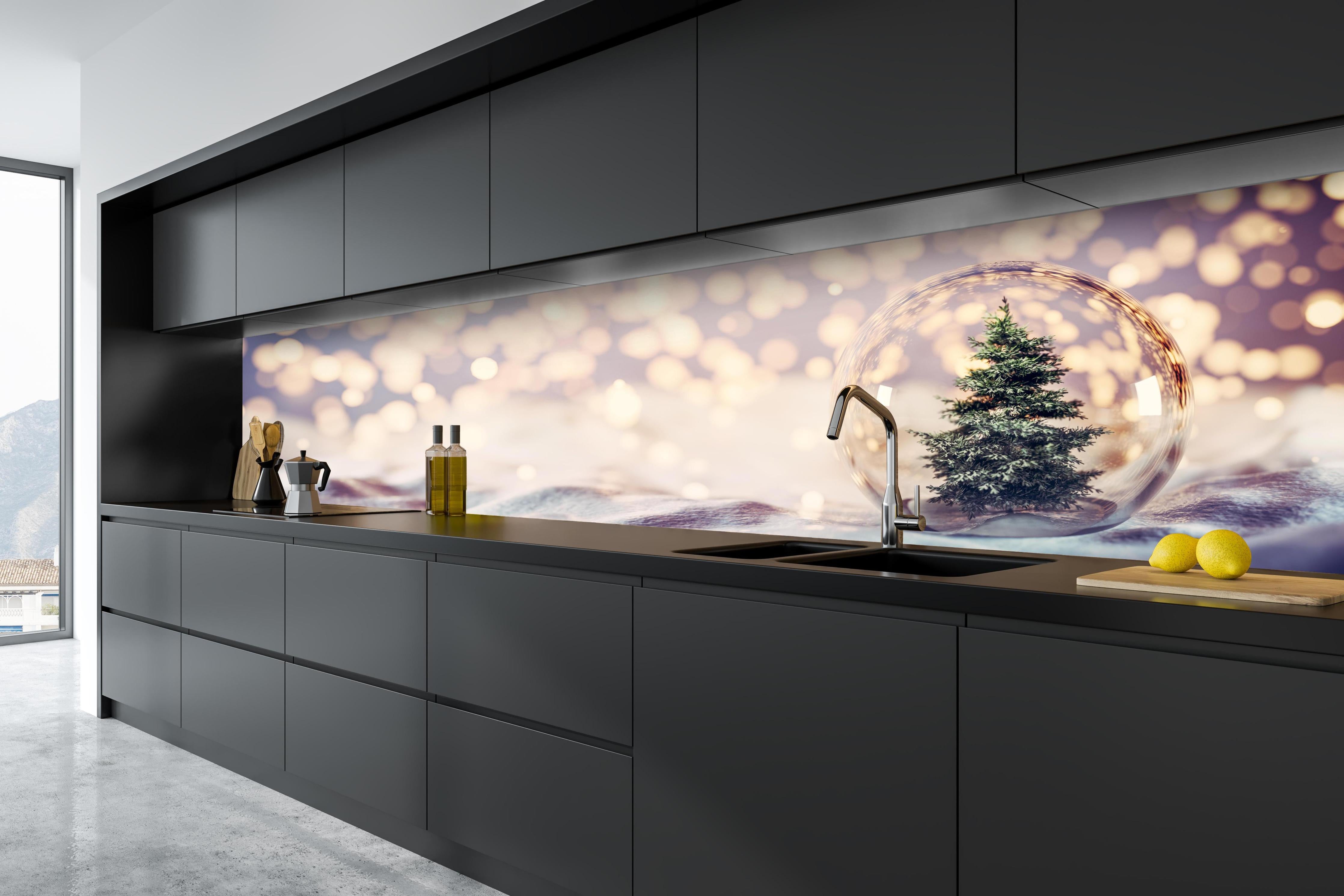 Küche - Weihnachtsbaum in einer Glaskugel hinter weißen Hochglanz-Küchenregalen und schwarzem Wasserhahn