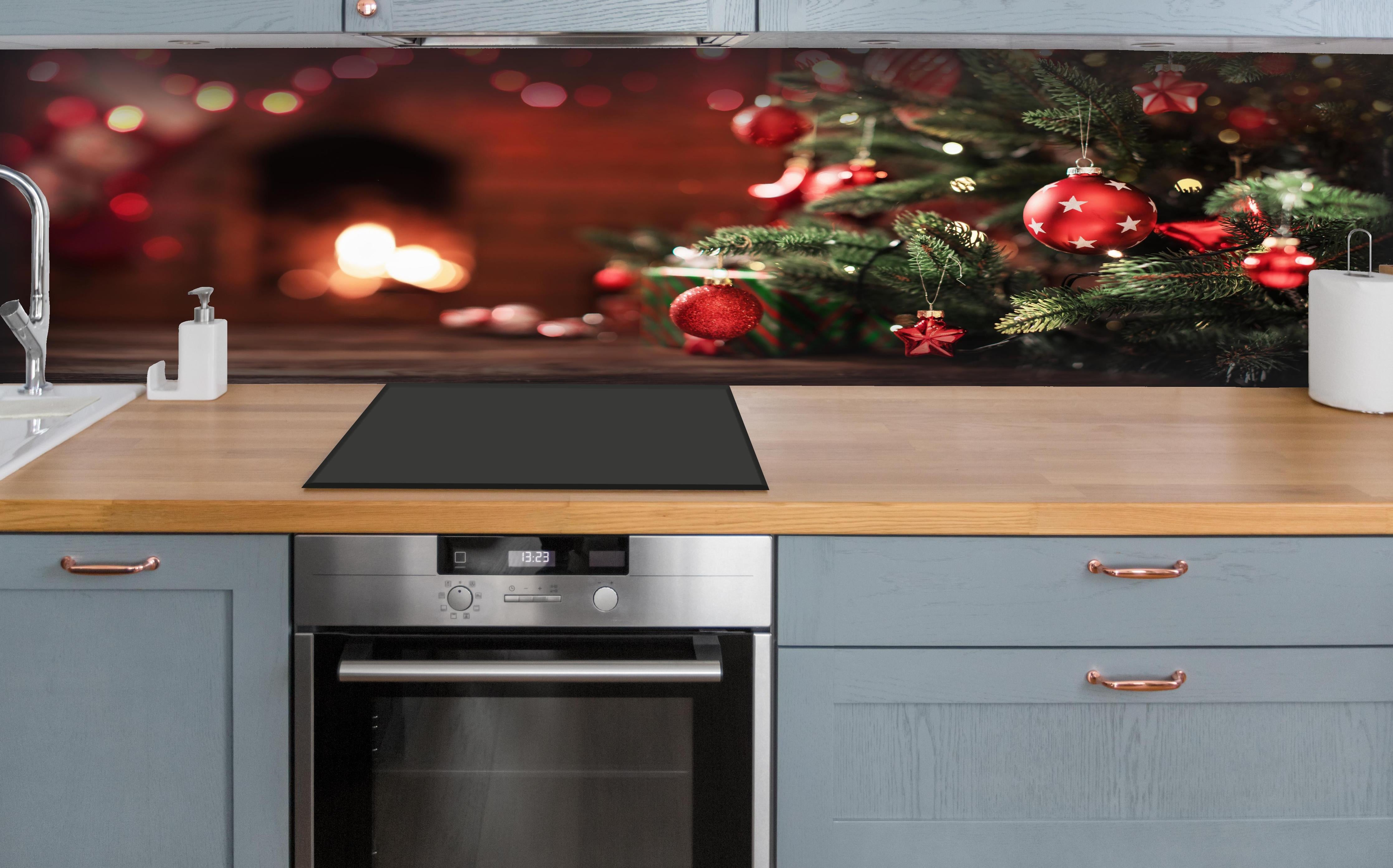 Küche - Weihnachtsbaum mit Dekorationen hinter weißen Hochglanz-Küchenregalen und schwarzem Wasserhahn